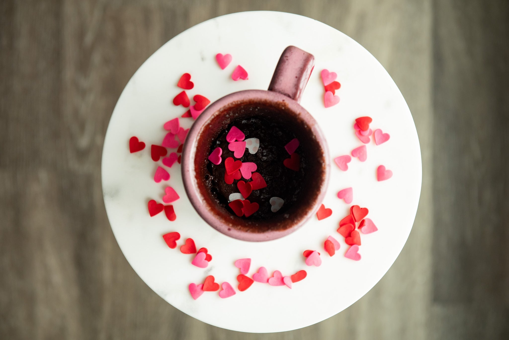 pink saratoga tea and honey mug filled with coco shou mug cake and pink and red heart sprinkles