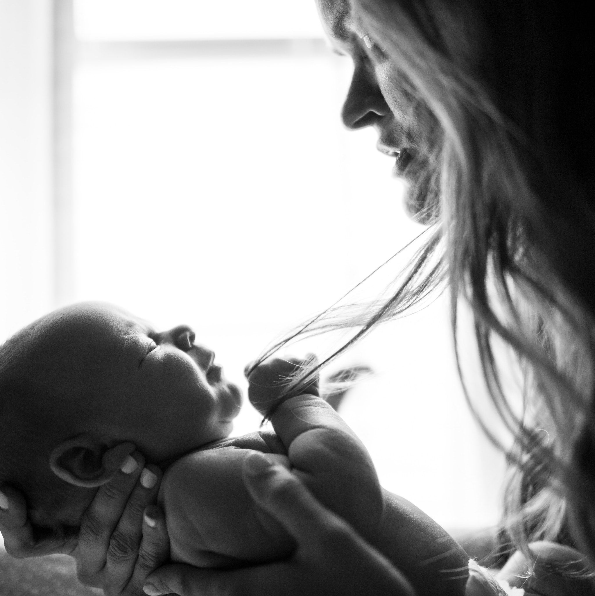 black and white photo of mom and new baby