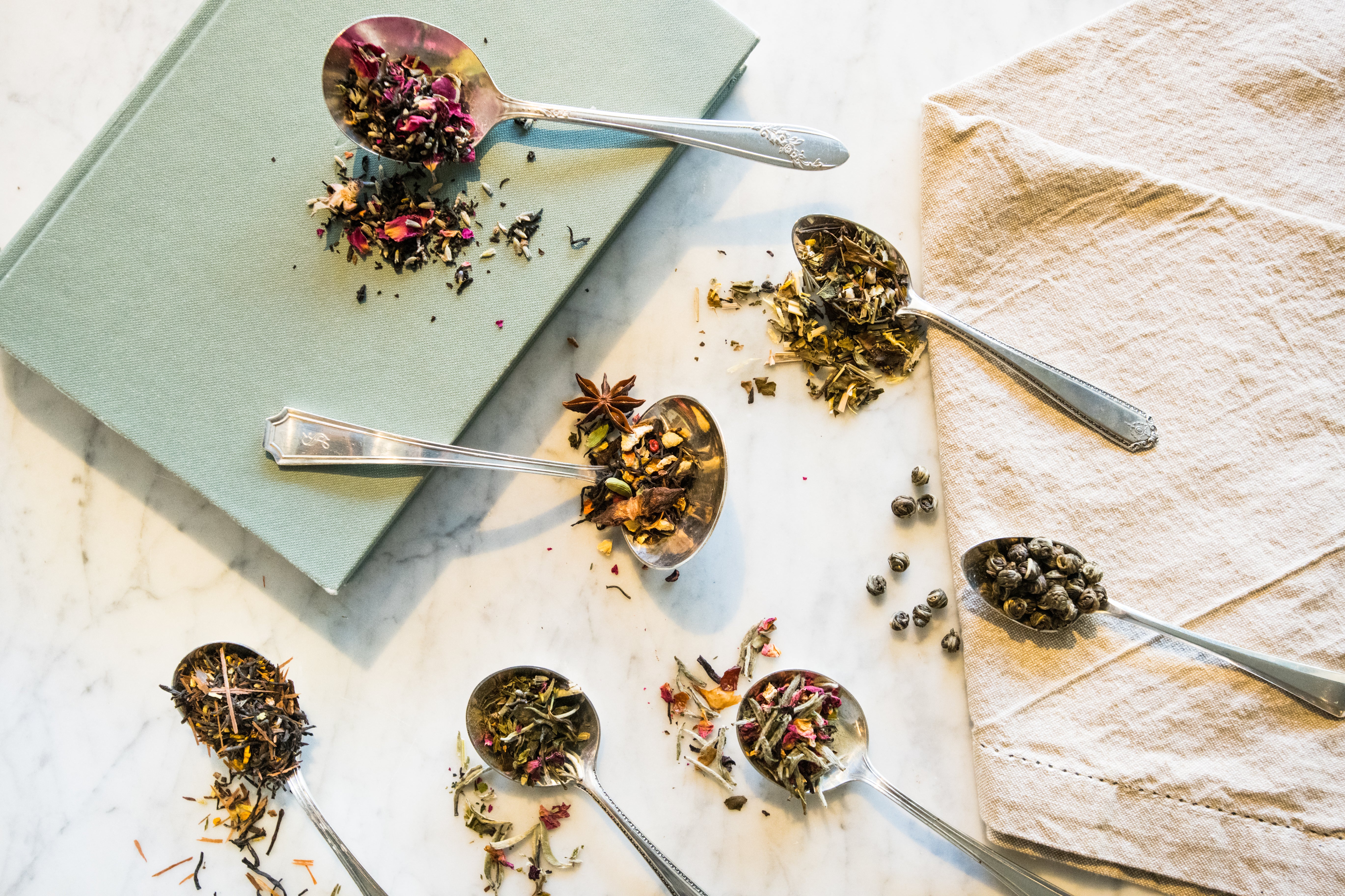 antique spoons spilling various teas