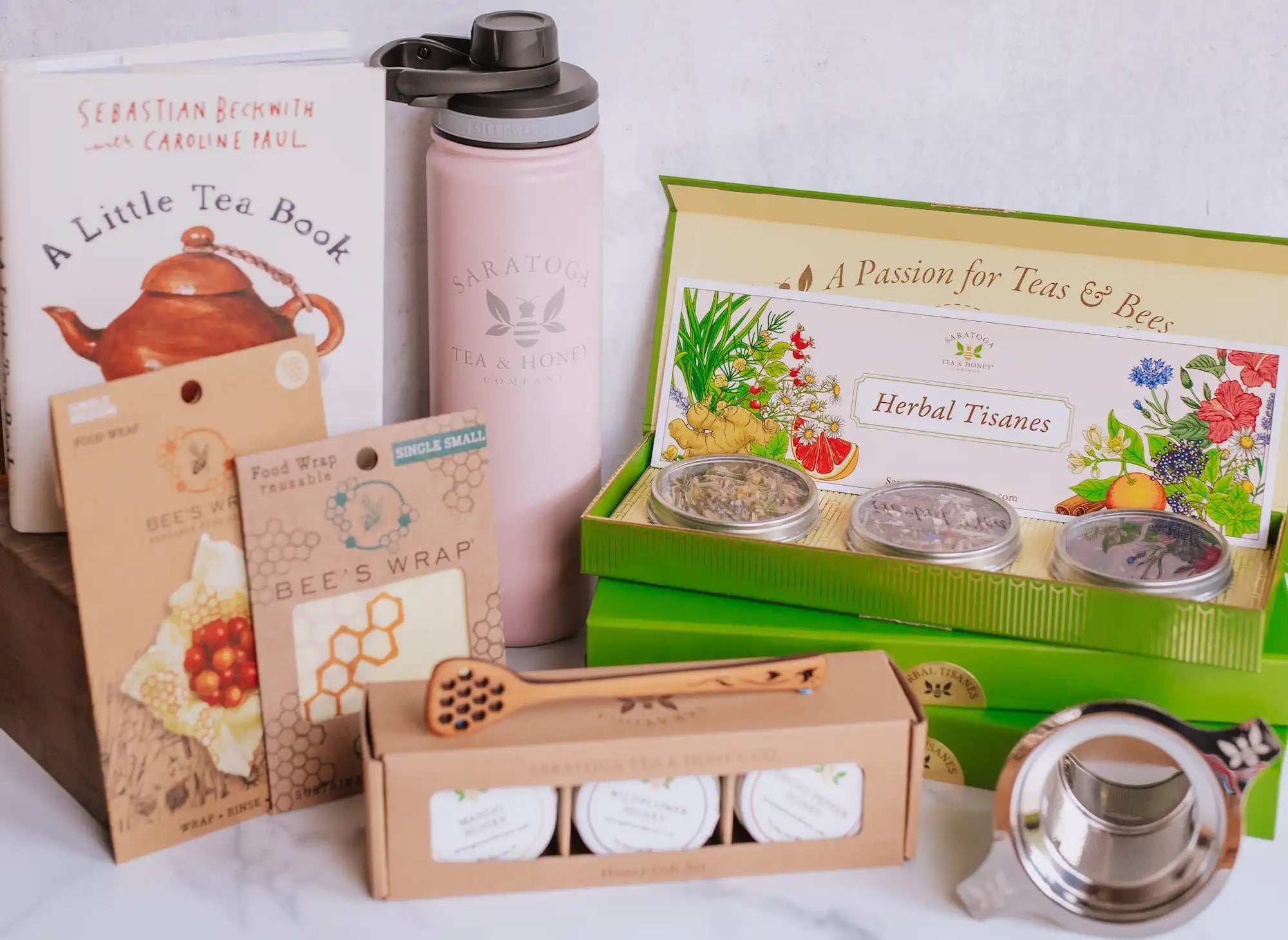 collection of tea and honey gifts including tea and honey sample sets, beeswax products, and tea tumblers