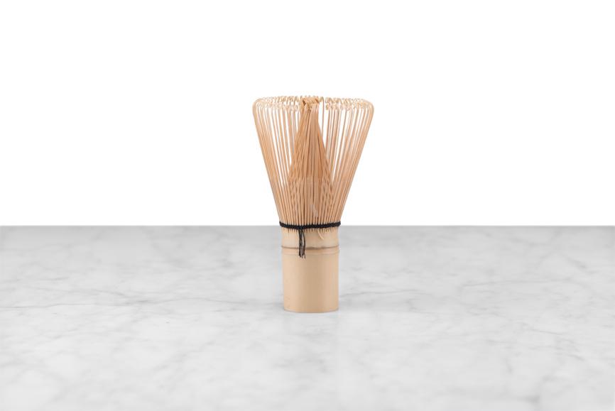 bamboo matcha whisk on a marble and white background