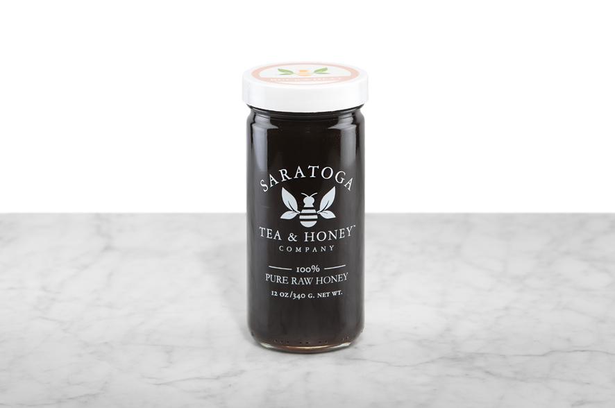 Opaque, black-brown Buckwheat Honey displayed in a 12oz cylindrical glass jar with a white lid. The logo and the words: "100% Pure Raw Honey" are printed on the jar.