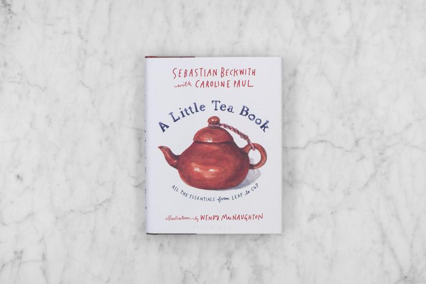 "A Little Tea Book" by Sebastian Beckwith with Caroline Paul. Closed, on a marble background.