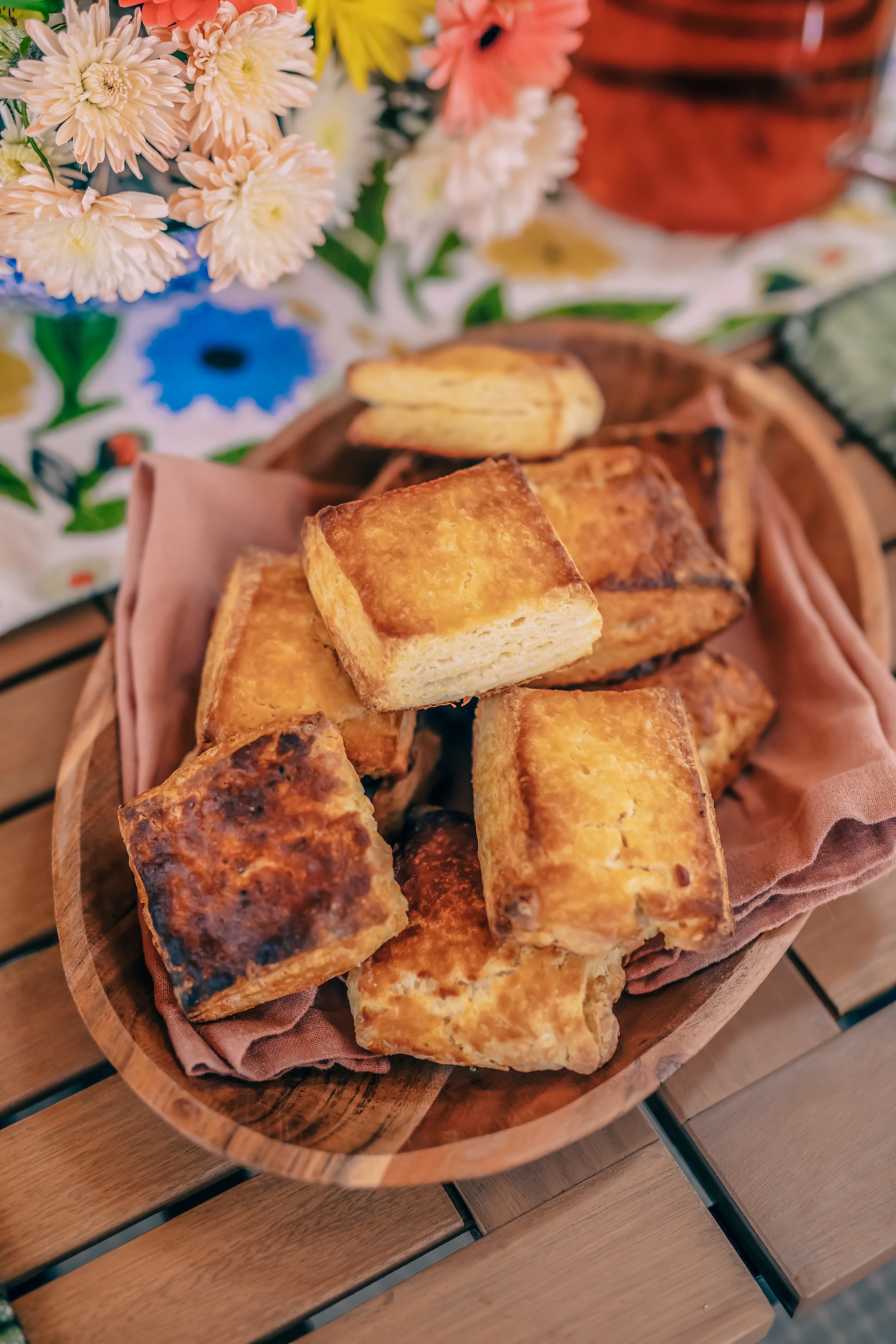 honey buttermilk biscuits in a wooden serving dish with a muted pink napkin