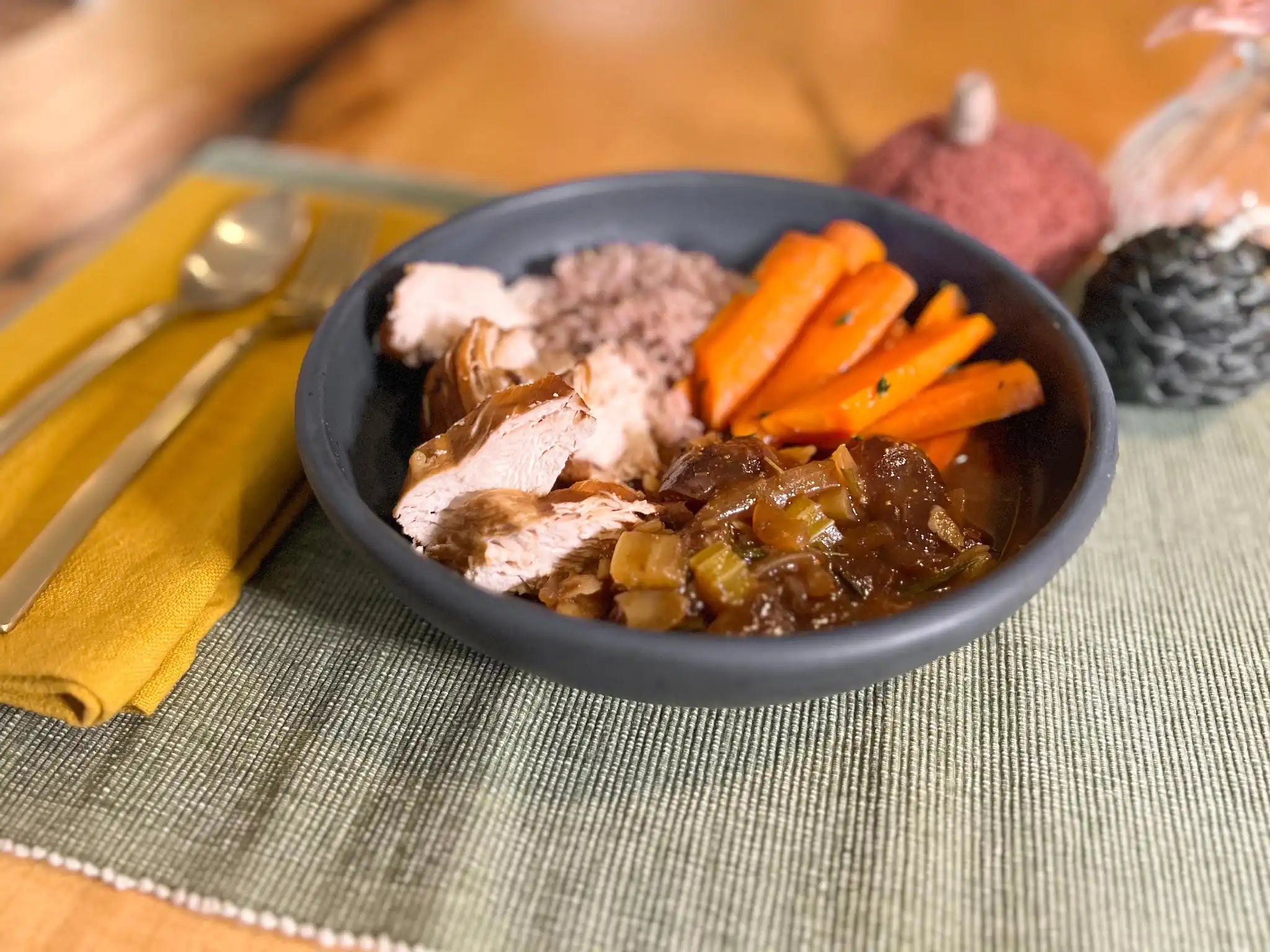 honey harvest chicken tagine served in a dark blue bowl with rice and carrots