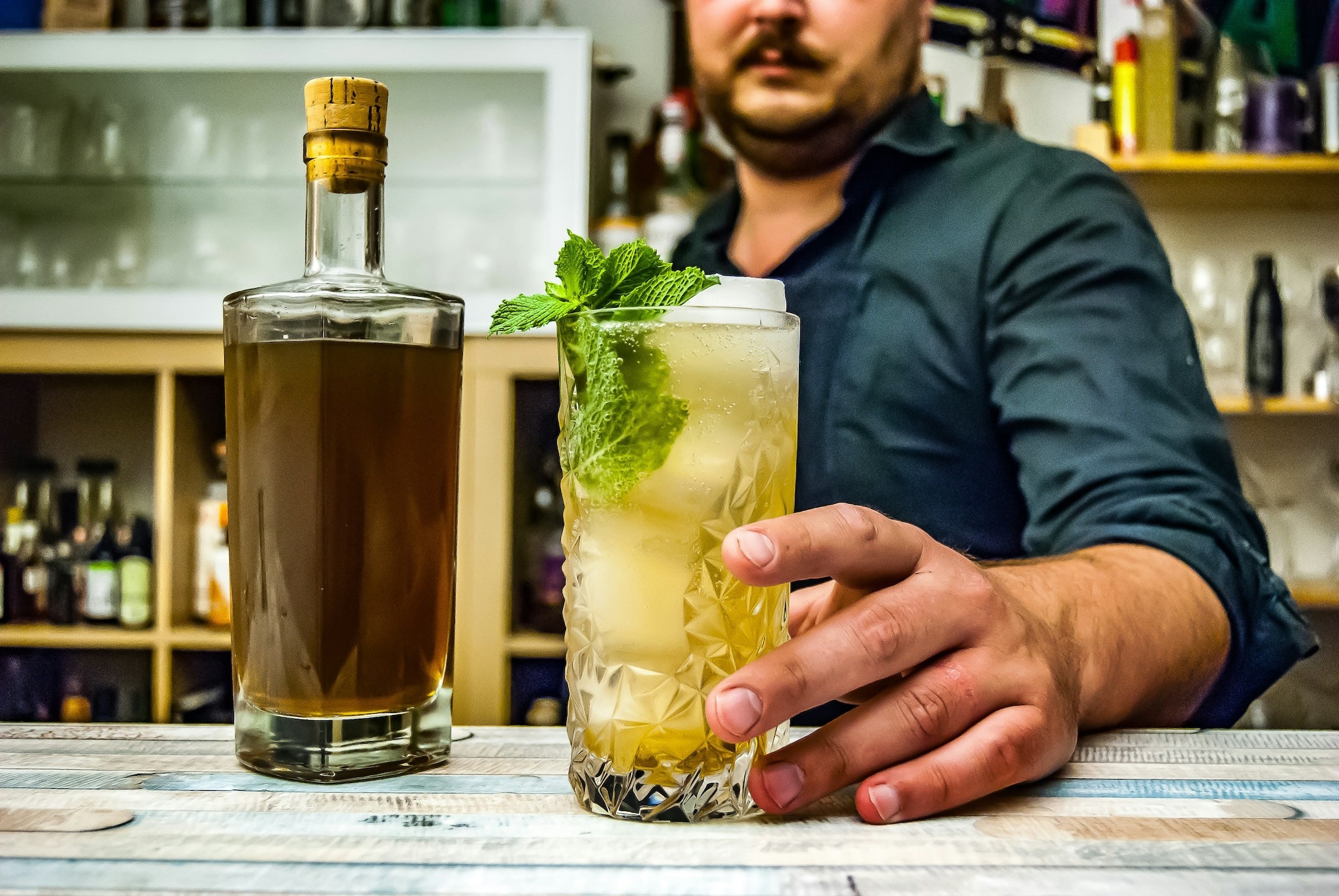 man presenting mint julep cocktail