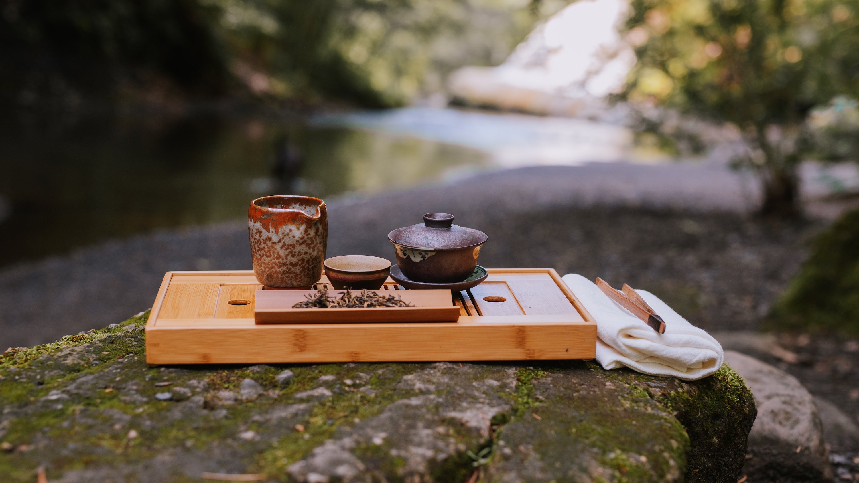 traditional tea brewing outside on a mossy rock