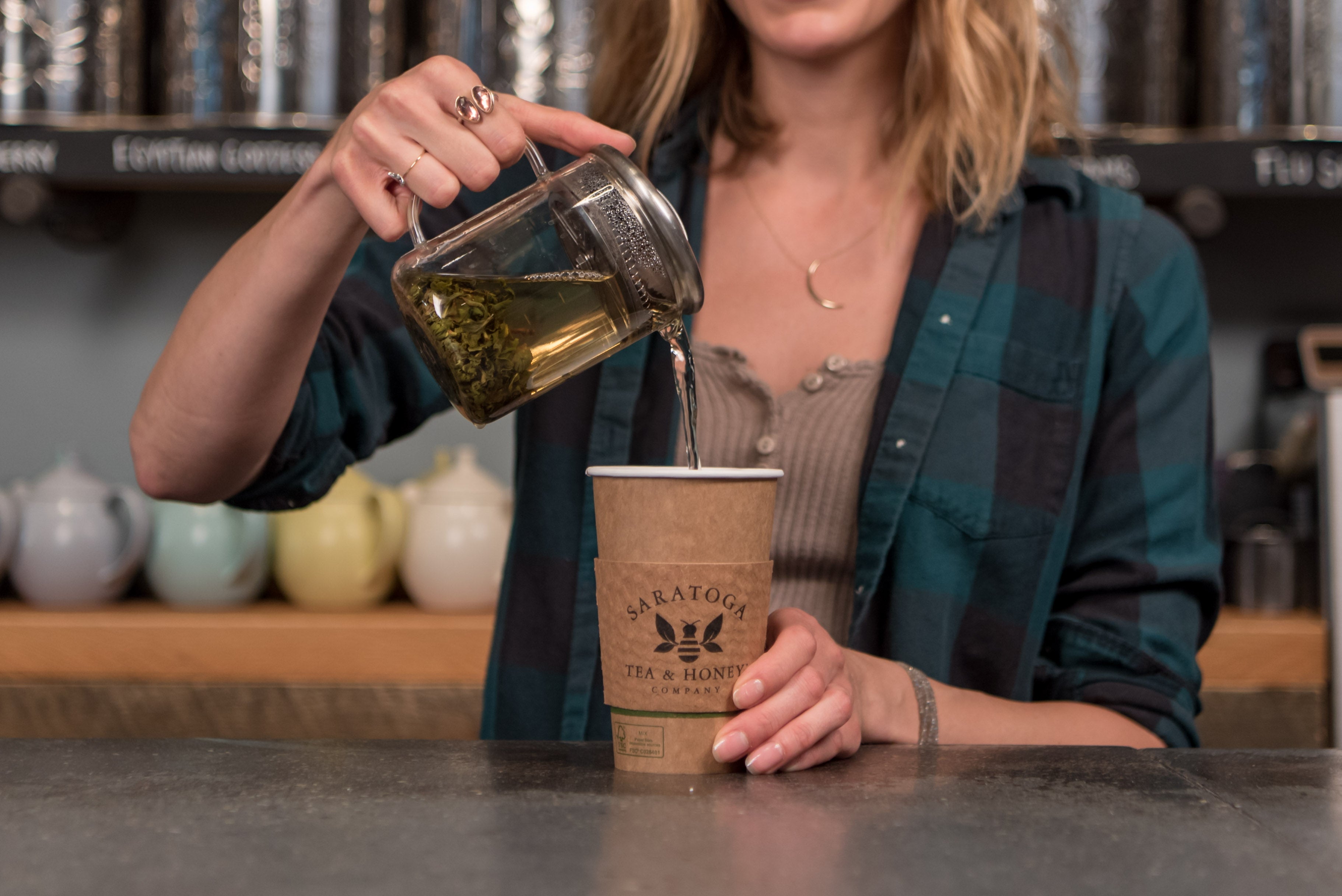 woman pouring tea into a to go cup from Saratoga Tea & Honey Co.