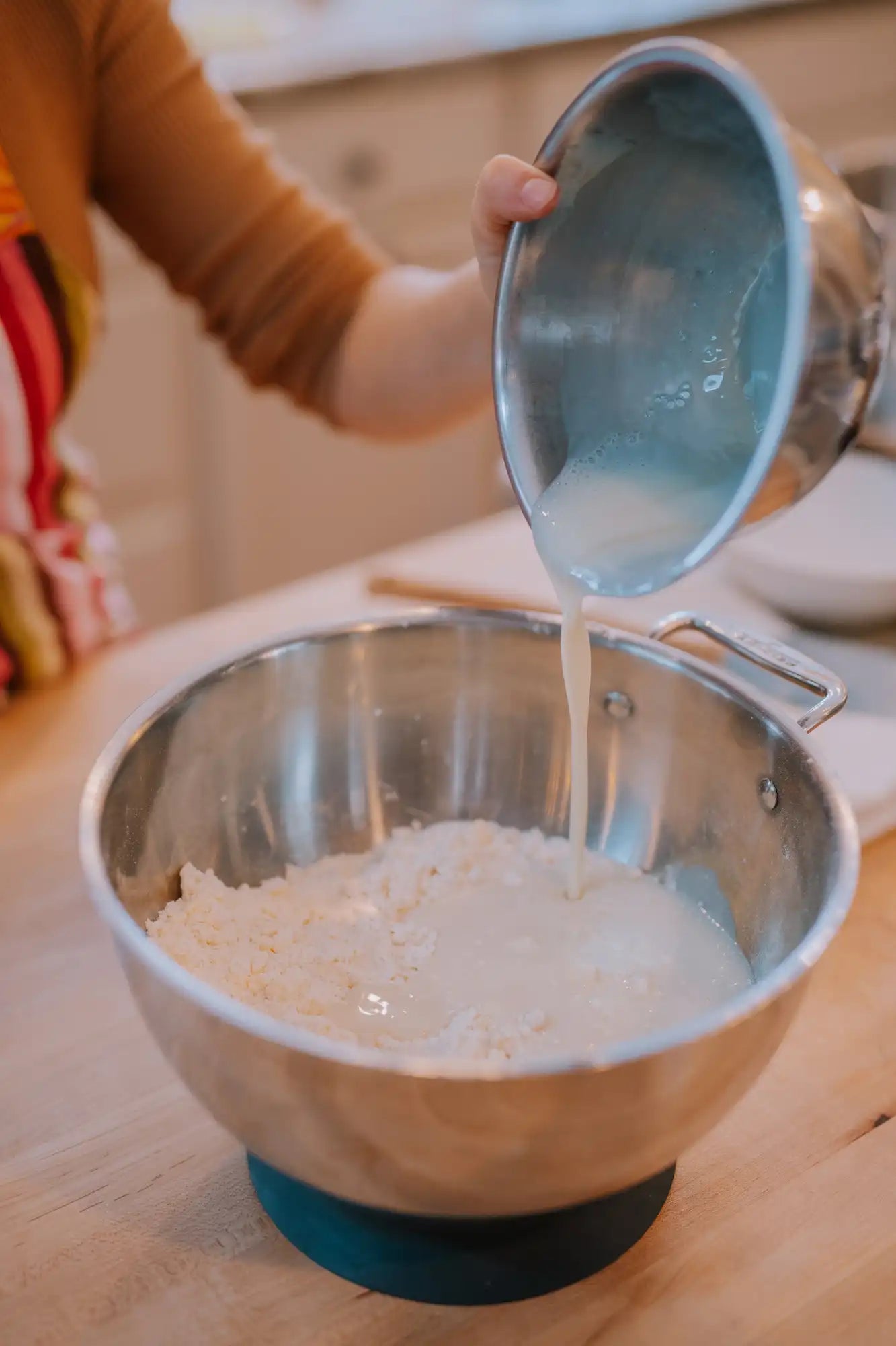 pouring honeyed buttermilk into dry ingredients for honey buttermilk biscuits