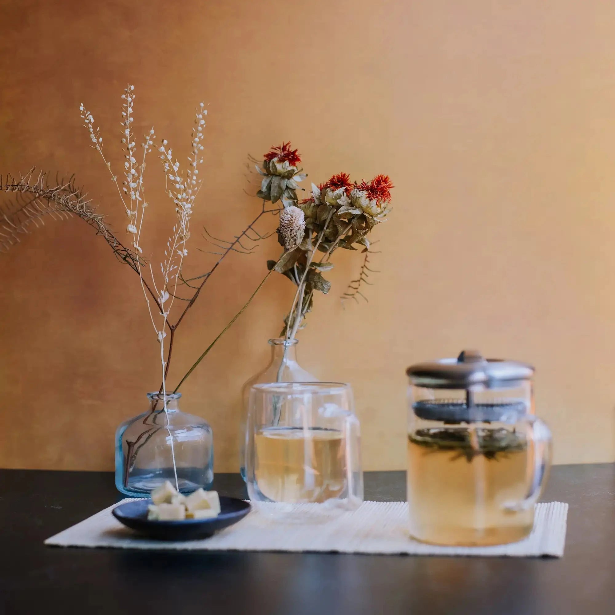 green tea brewing in a glass beaker next to a glass mug of green tea and mung bean candy bar squares