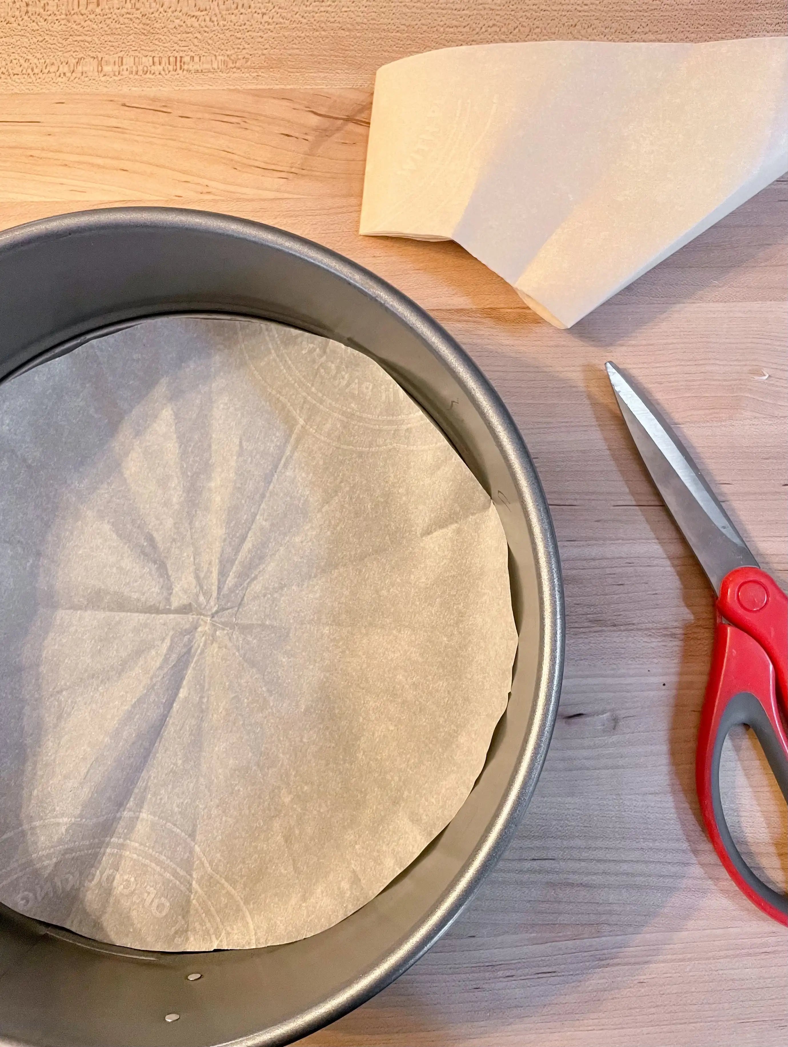 prepping cake pan with parchment paper