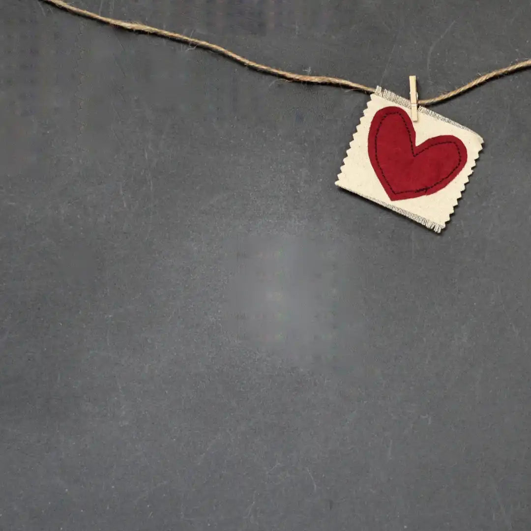 felt red heart clothespinned to twine on a slate background