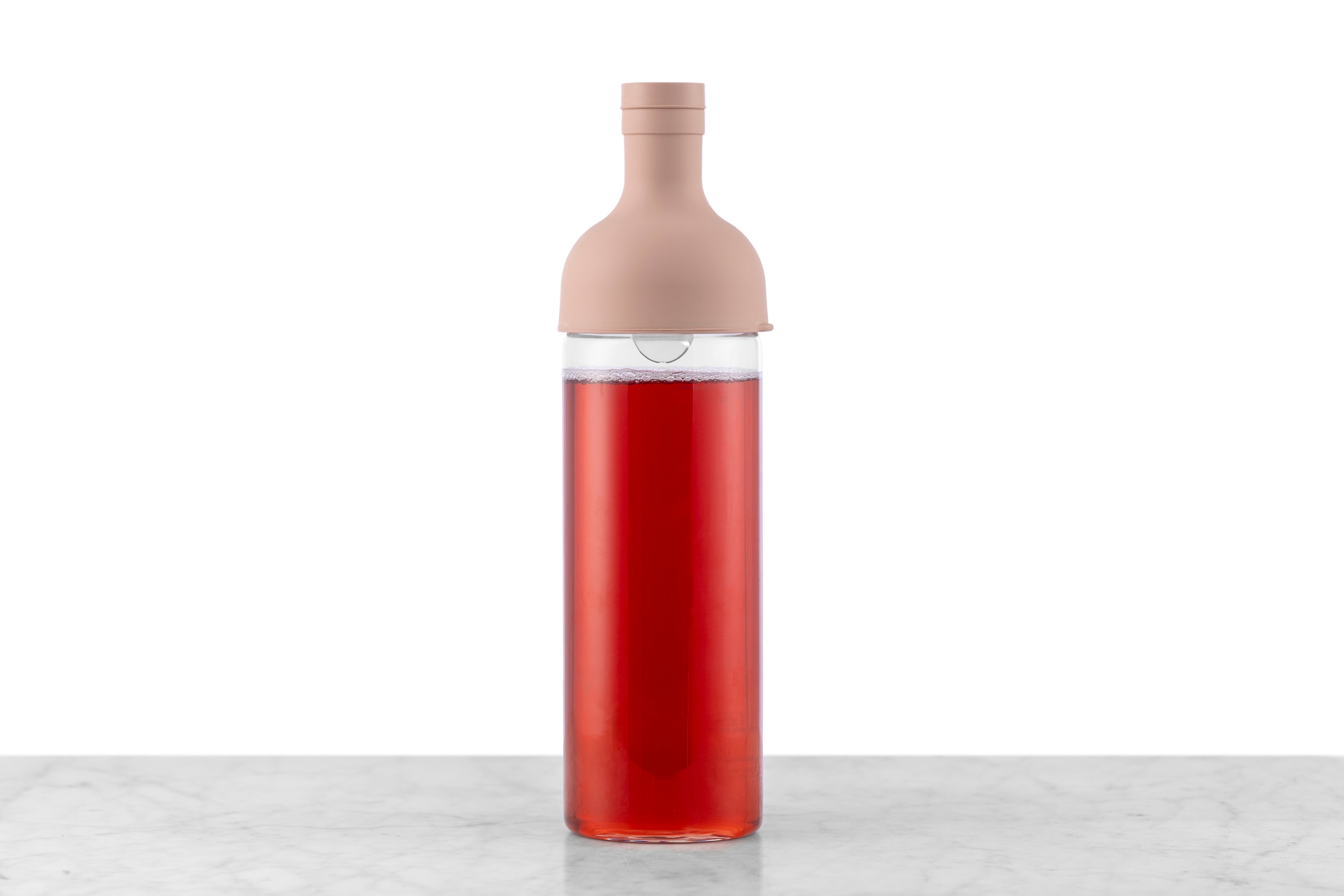 A glass wine bottle-style iced tea maker in Smokey Pink.