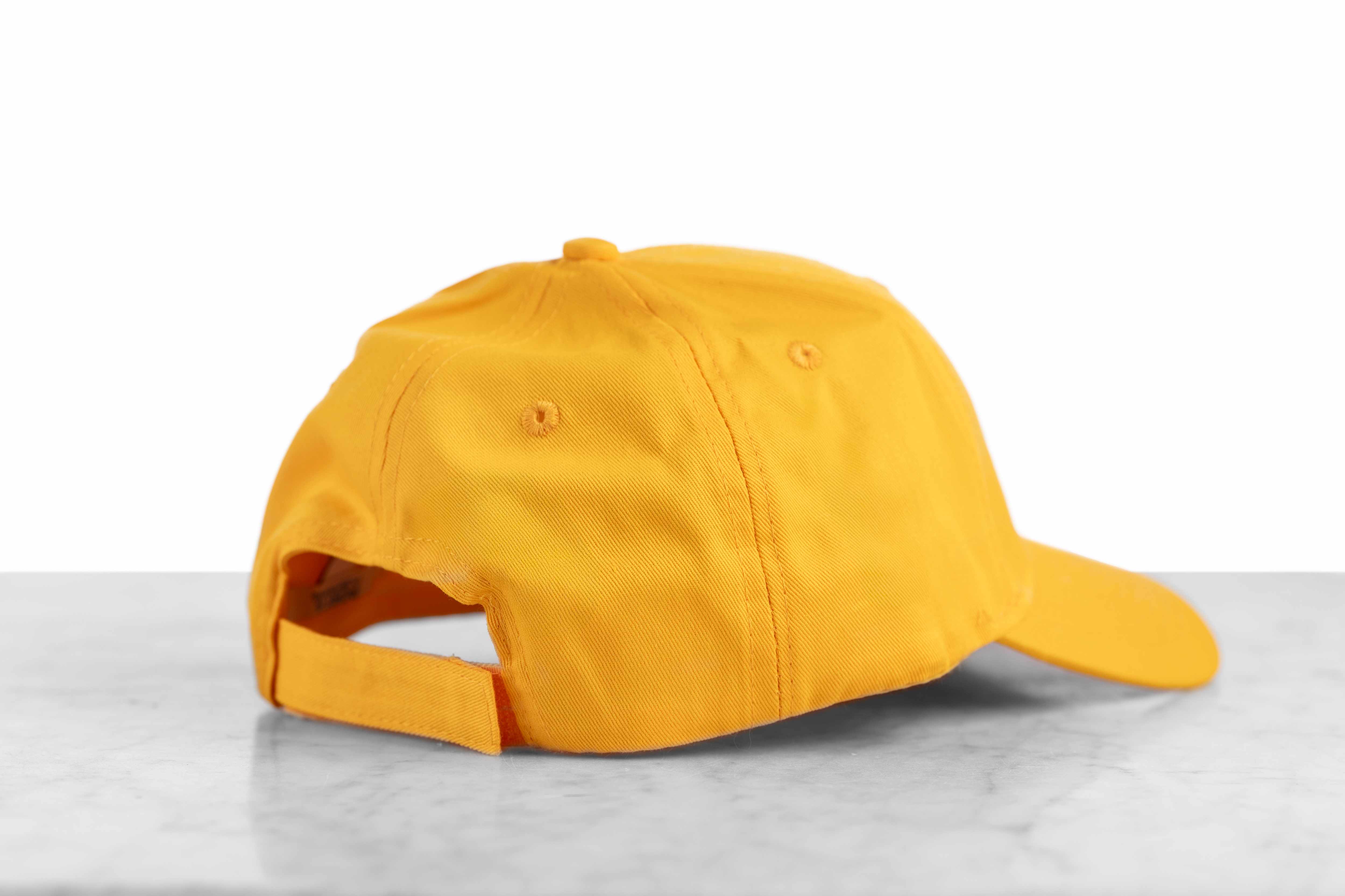 The back of a yellow baseball cap with a velcro size adjustor.