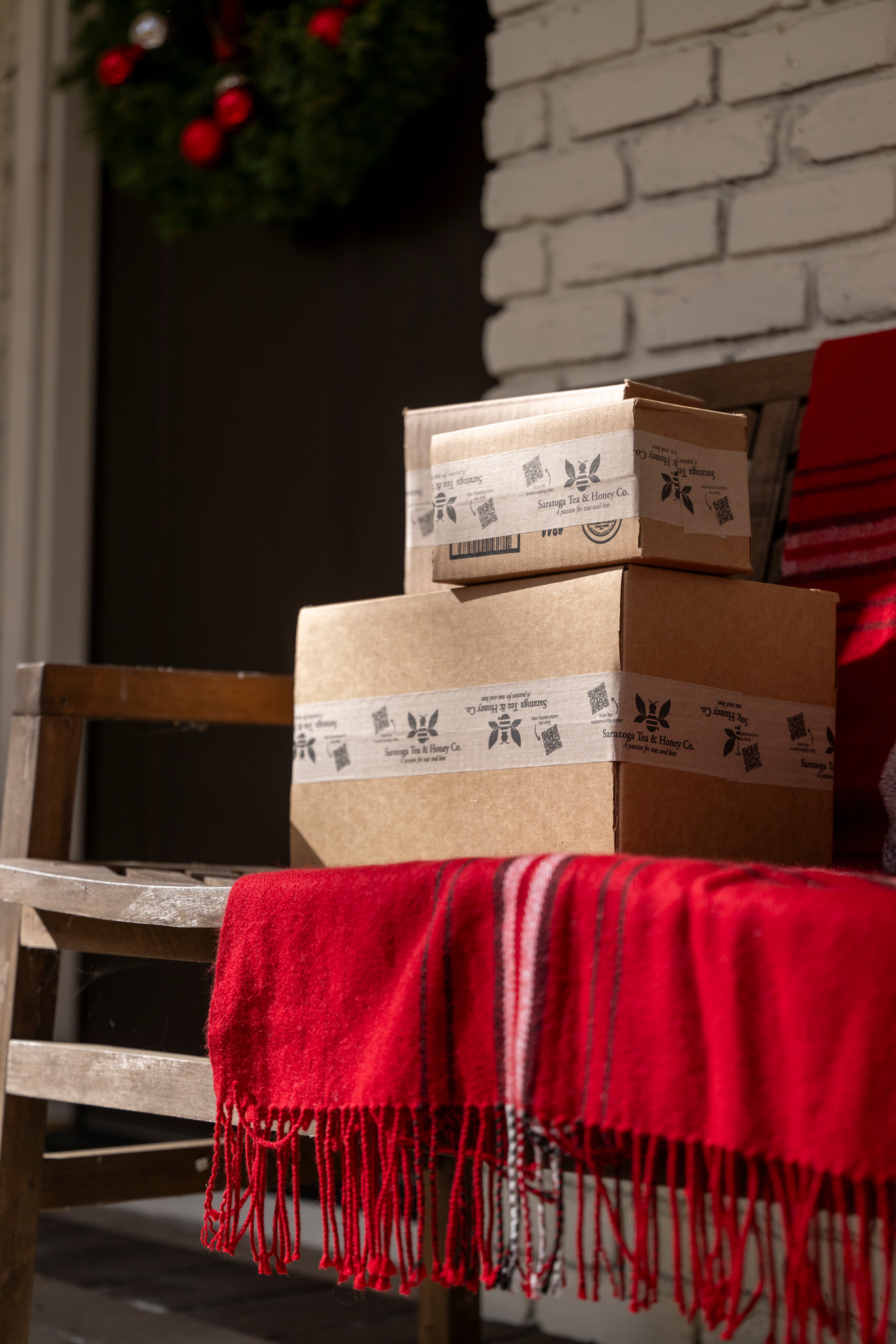 Packages from Saratoga Tea and Honey Company on a front porch.