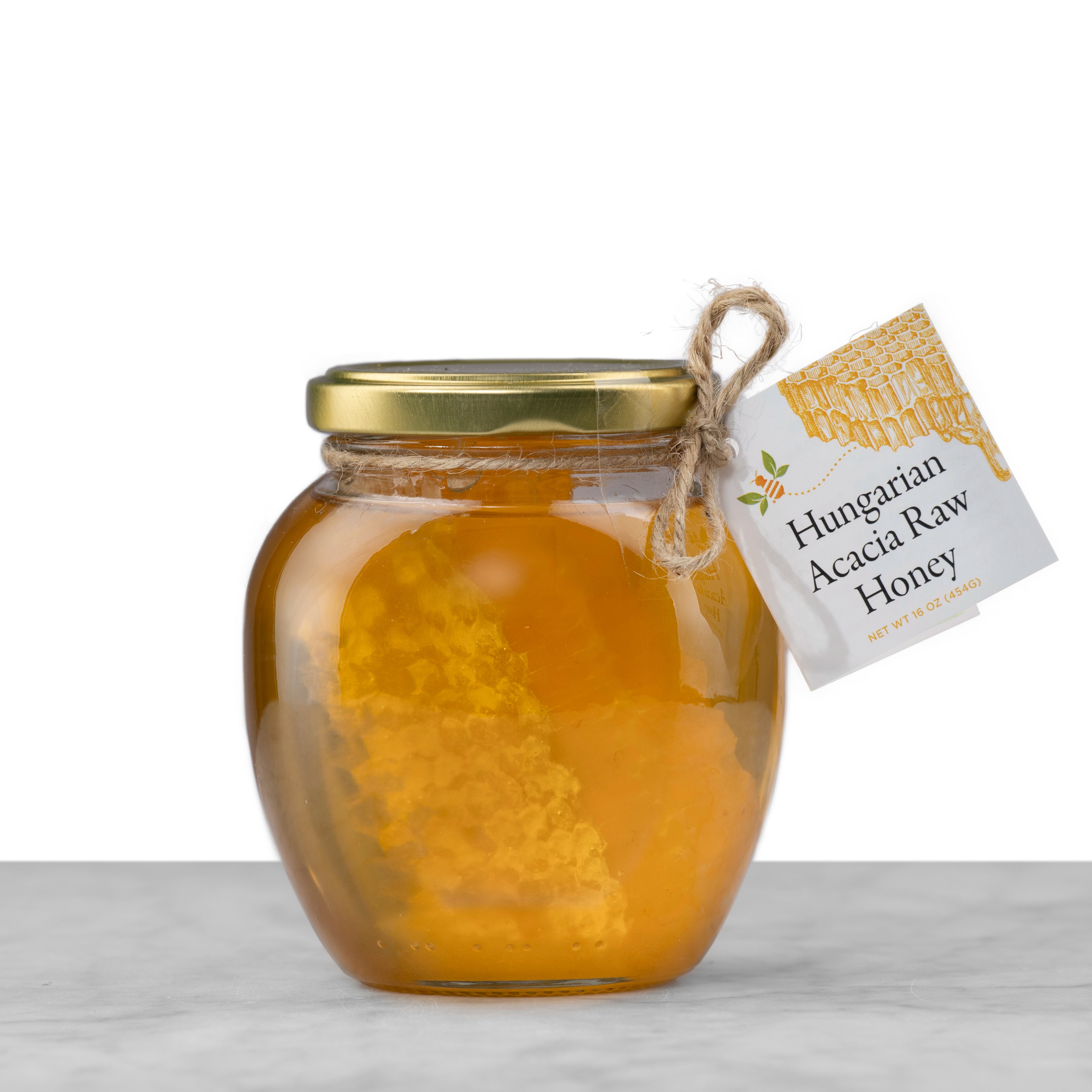A small rounded jar of Hungarian Acacia Honeycomb coated in honey.