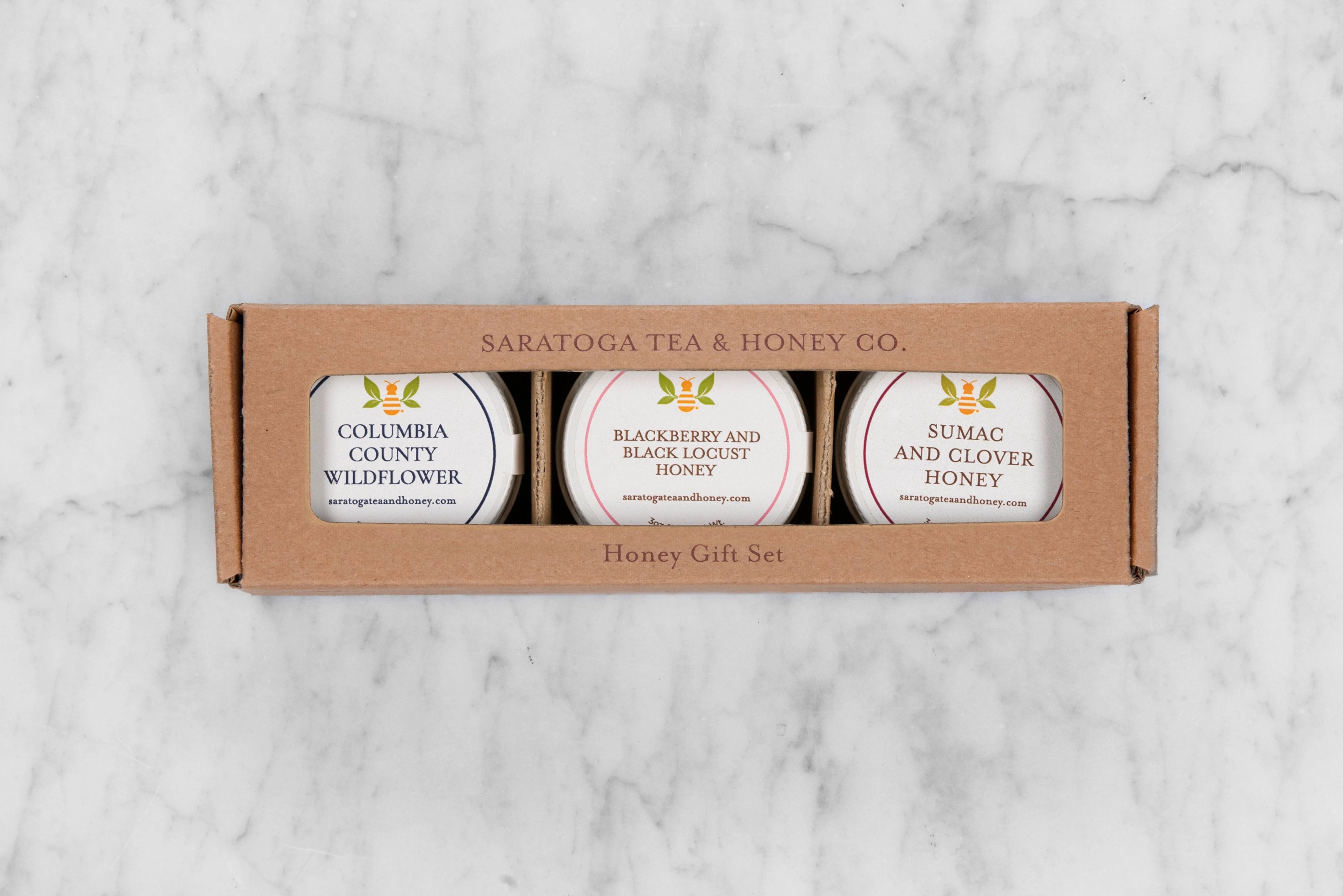 kraft box with an opening showing three mini honey jars of local Upstate NY honeys: Columbia County Wildflower, Blackberry & Black Locust, and Sumac and Clover Honey