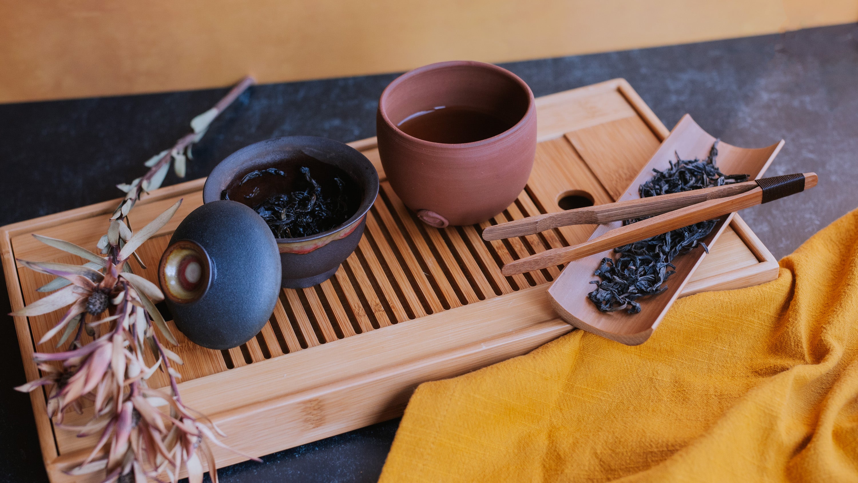 gaiwan of dark oolong on teabot with tea bowl