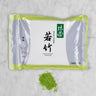 Matcha Wakatake 100g Pouch centered on marble with example pile of matcha green tea powder
