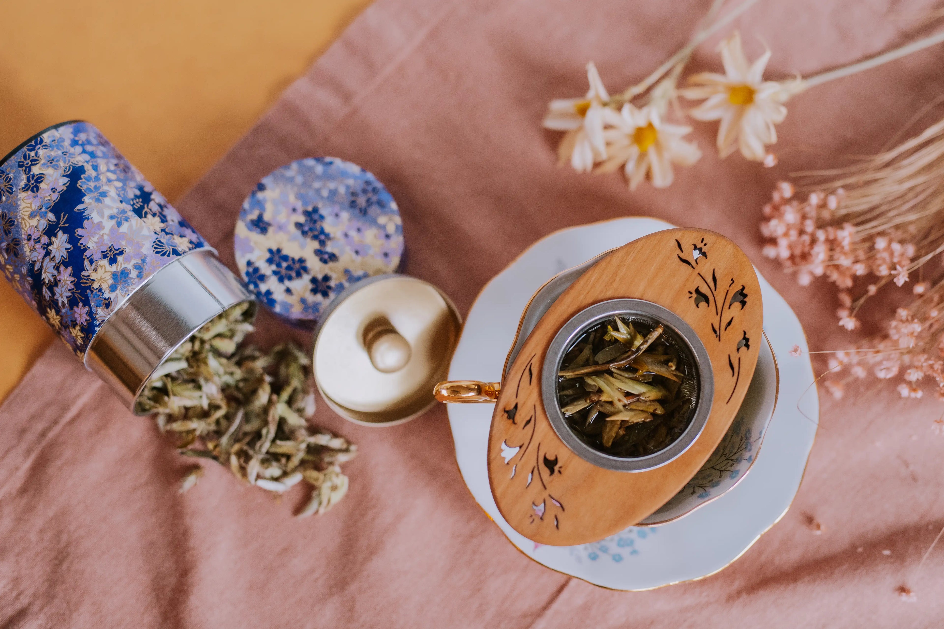 aerial view of nan mei wild buds white tea steeping in a moonspoon infuser with flower motif