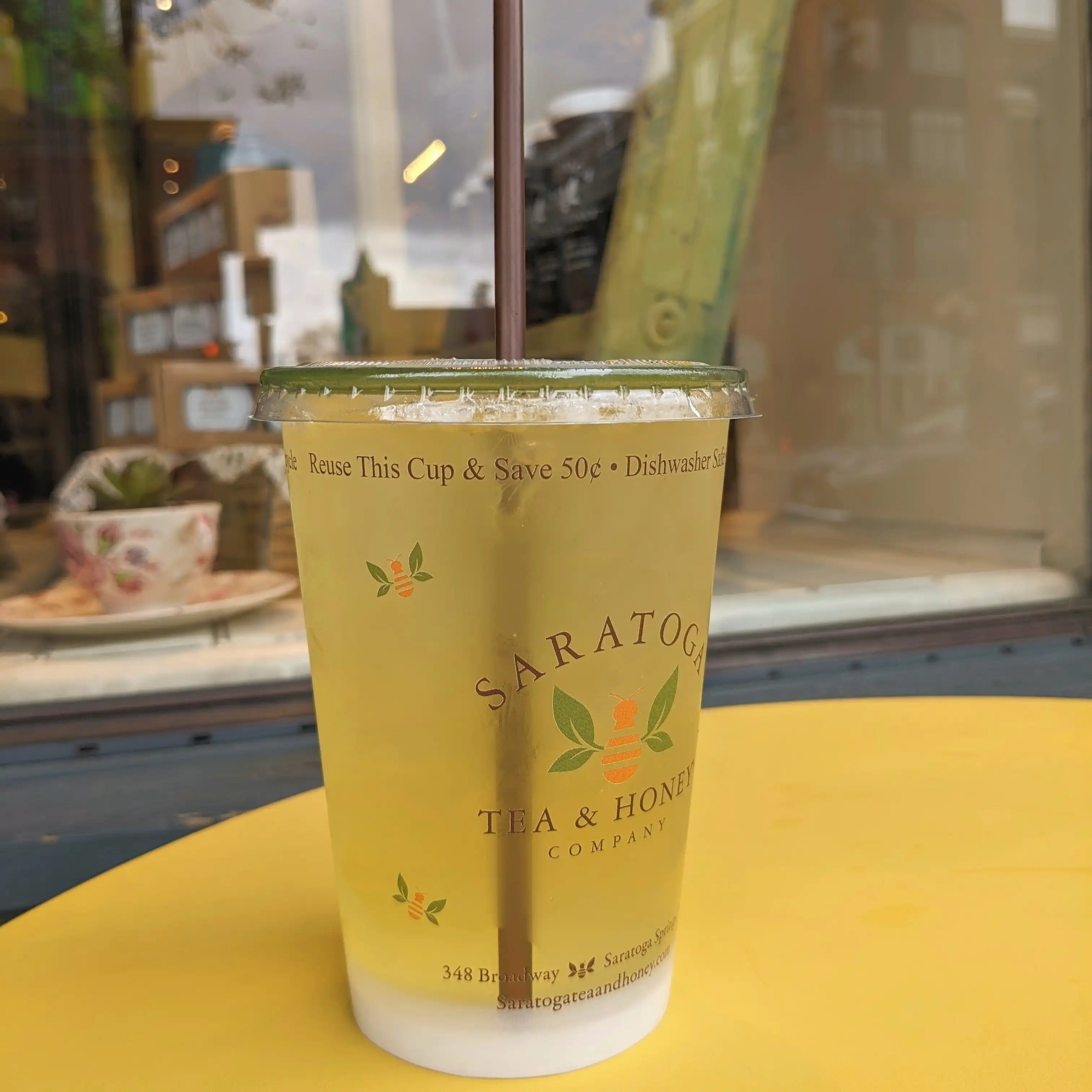 photo of reusable Saratoga Tea & Honey iced tea cup filled with green tea and a bioplastic straw