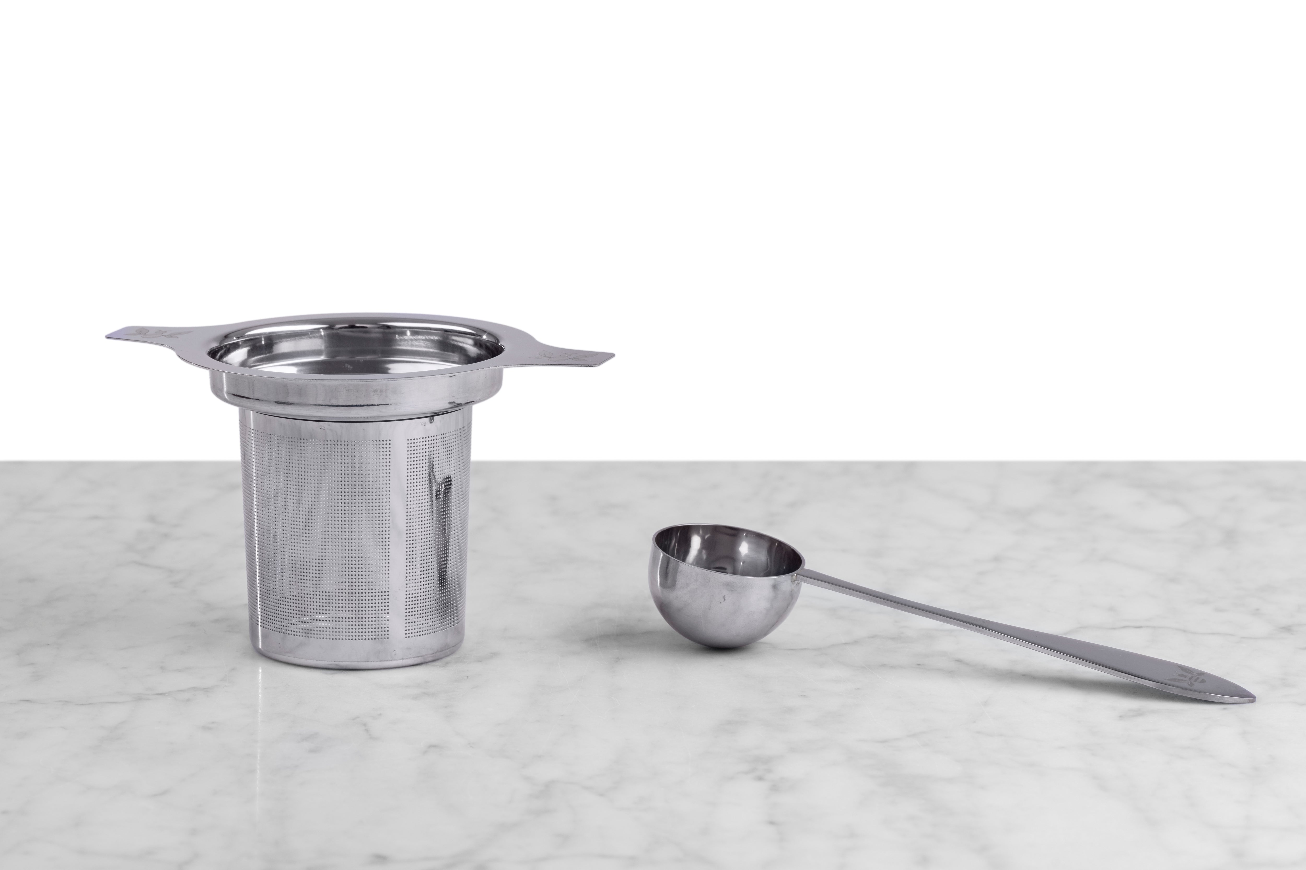 stainless steel tea infuser next to stainless steel tea scoop