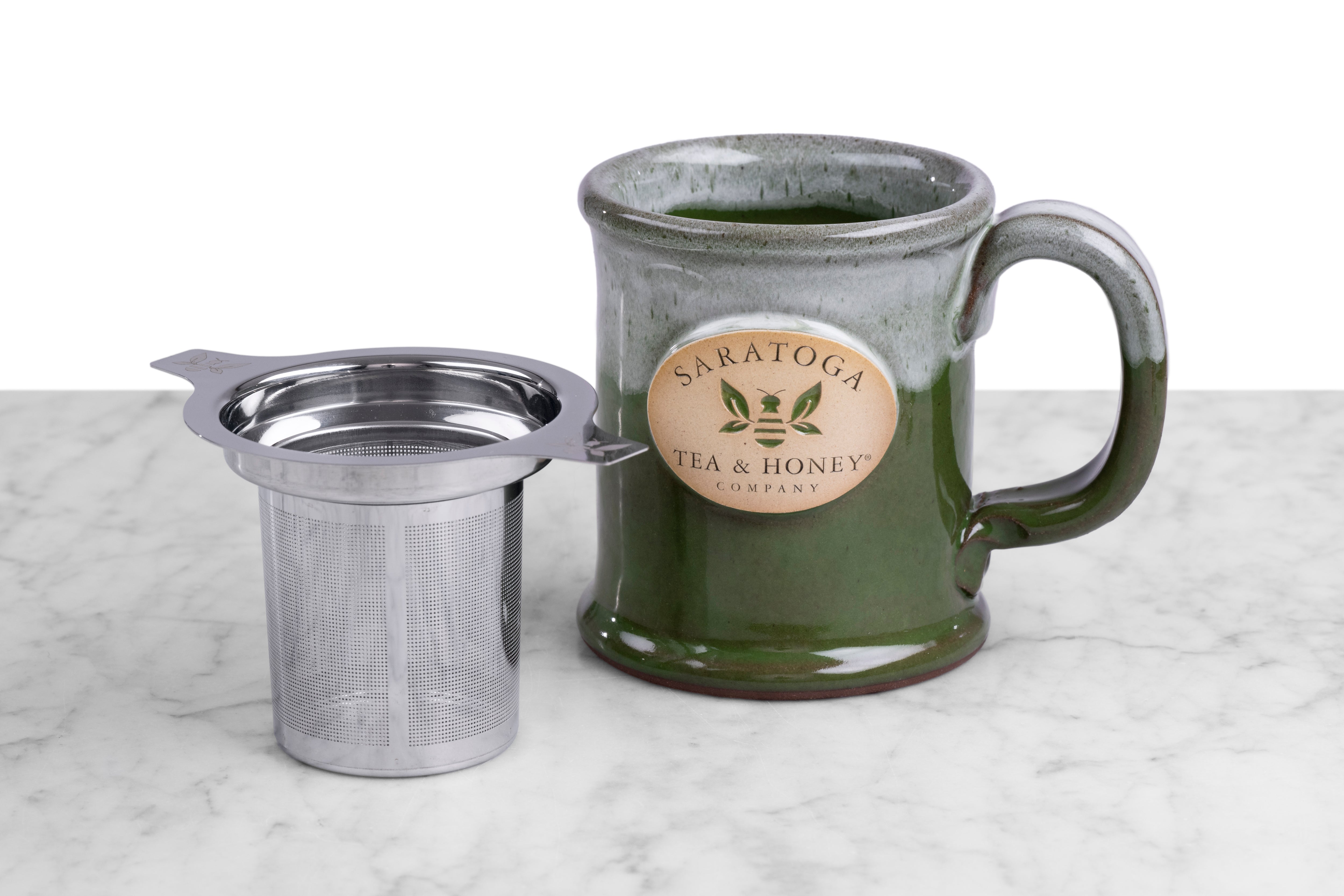 saratoga tea and honey co mug and stainless steel infuser bundle on a mabrle and white background