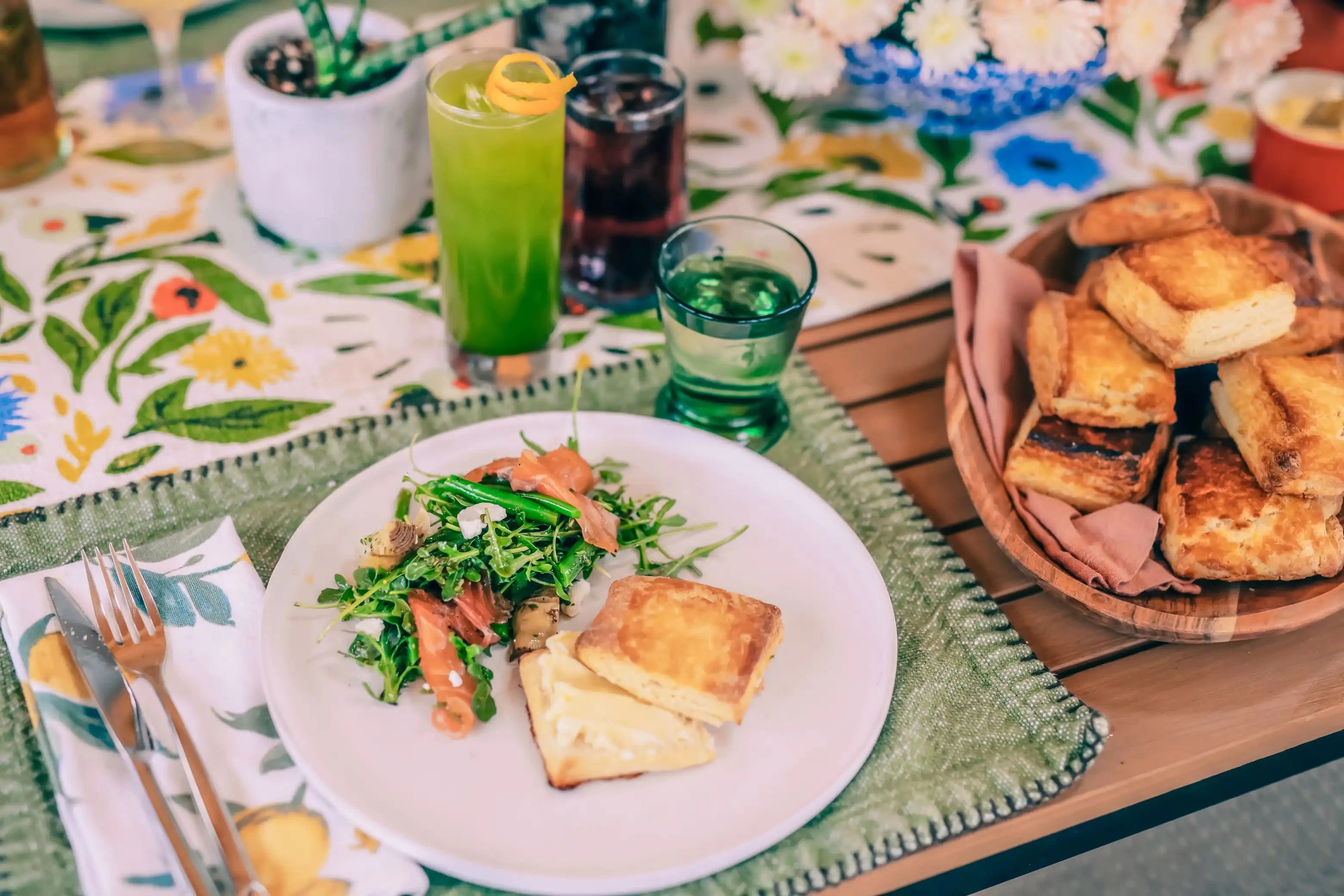 platter of honey buttermilk biscuits next to a white plate with salmon salad and cut buttermilk biscuit with honeybutter