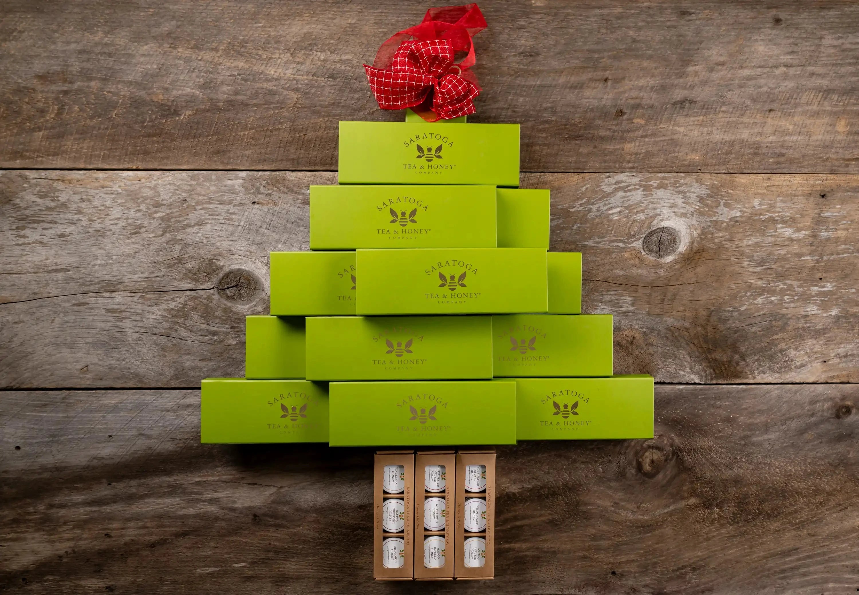 Christmas tree made from Saratoga Tea & Honey Co tea and honey gift sets on a wood background