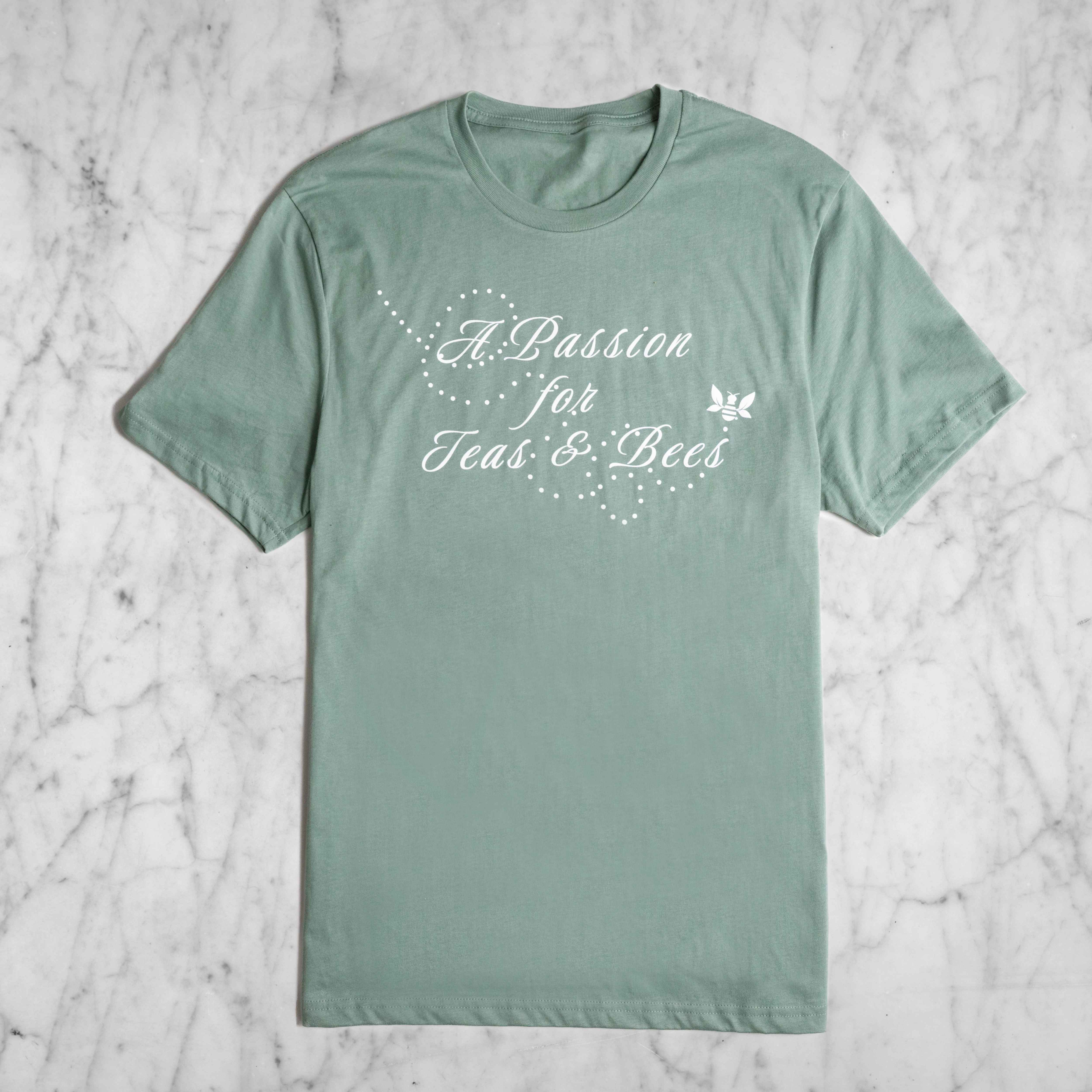A light sage green short sleeved shirt with the phrase "A Passion for Teas and Bees" on the front.