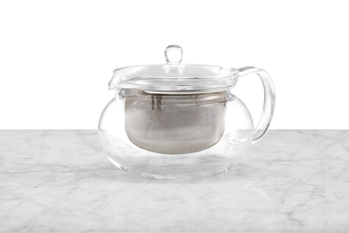 A glass teapot with a metal infuser.