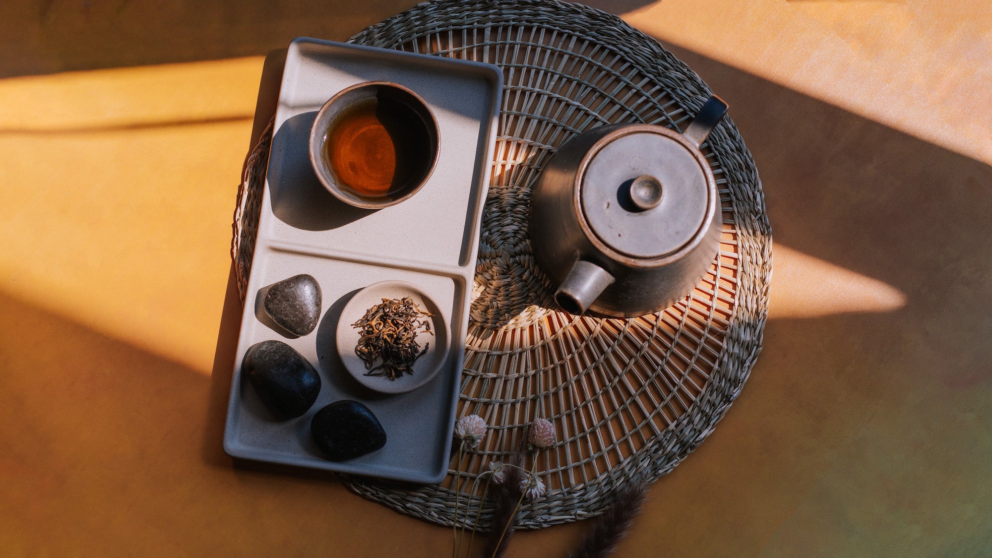 aerial view of modern ceramic teapot with brewed black tea and loose leaf black tea on a yellow background