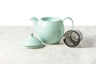 showing three main parts of the dew teapot in minty aqua: lid with silicone ring, teapot, and stainless steel basket infuser