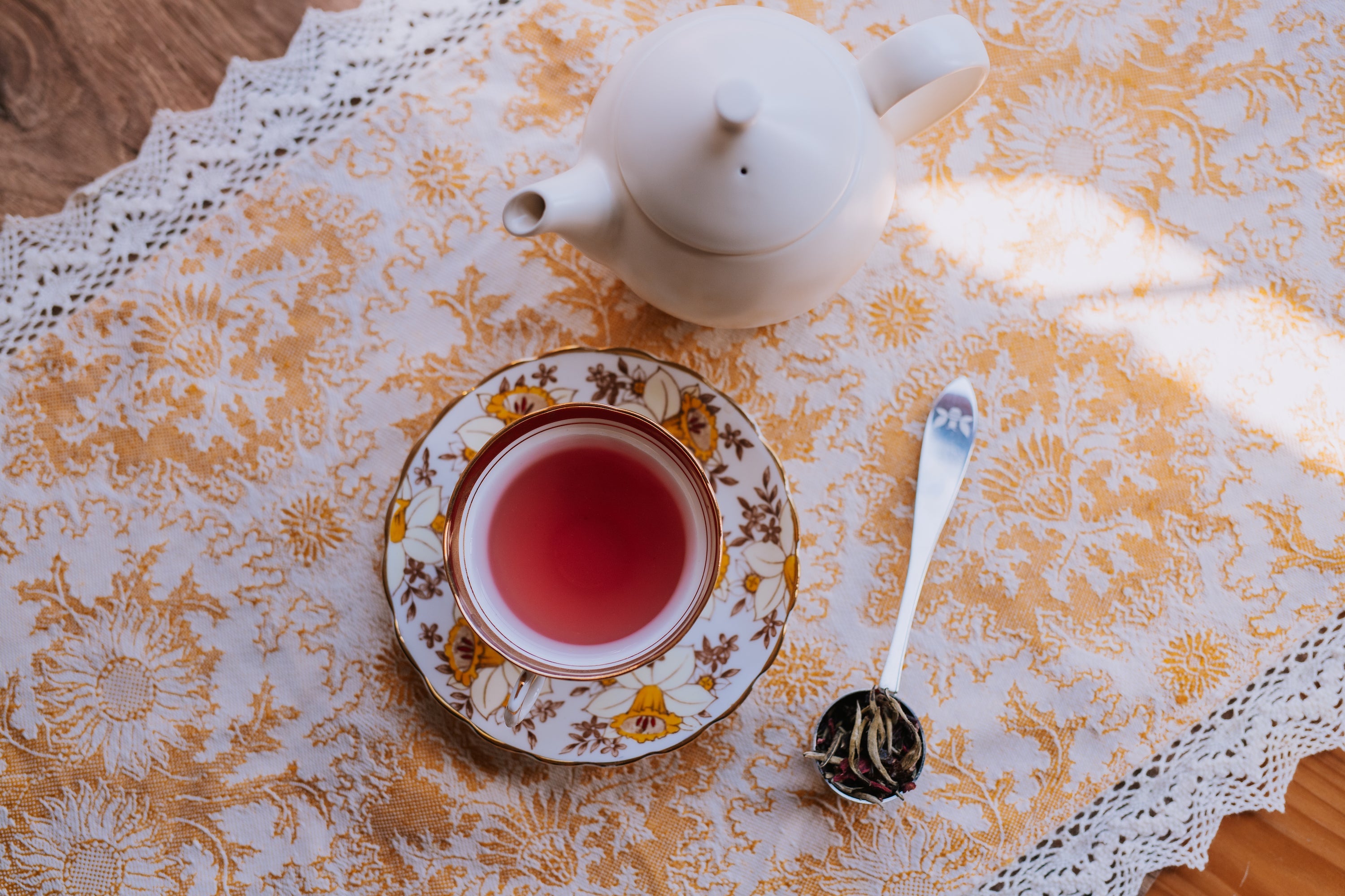 teapot with vintage tea cup and tea scoop full of tea