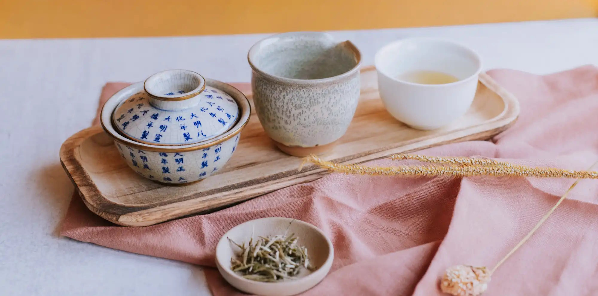 gaiwan with silverneedle white tea and white teacups on a wooden board
