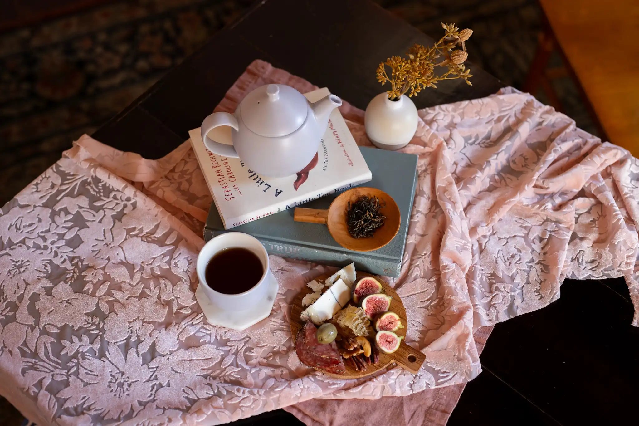 Yunnan Da Ye Chinese black tea served in lavender colored dew teapot and matching cup with a dish of loose leaf black tea and a charcuterie board