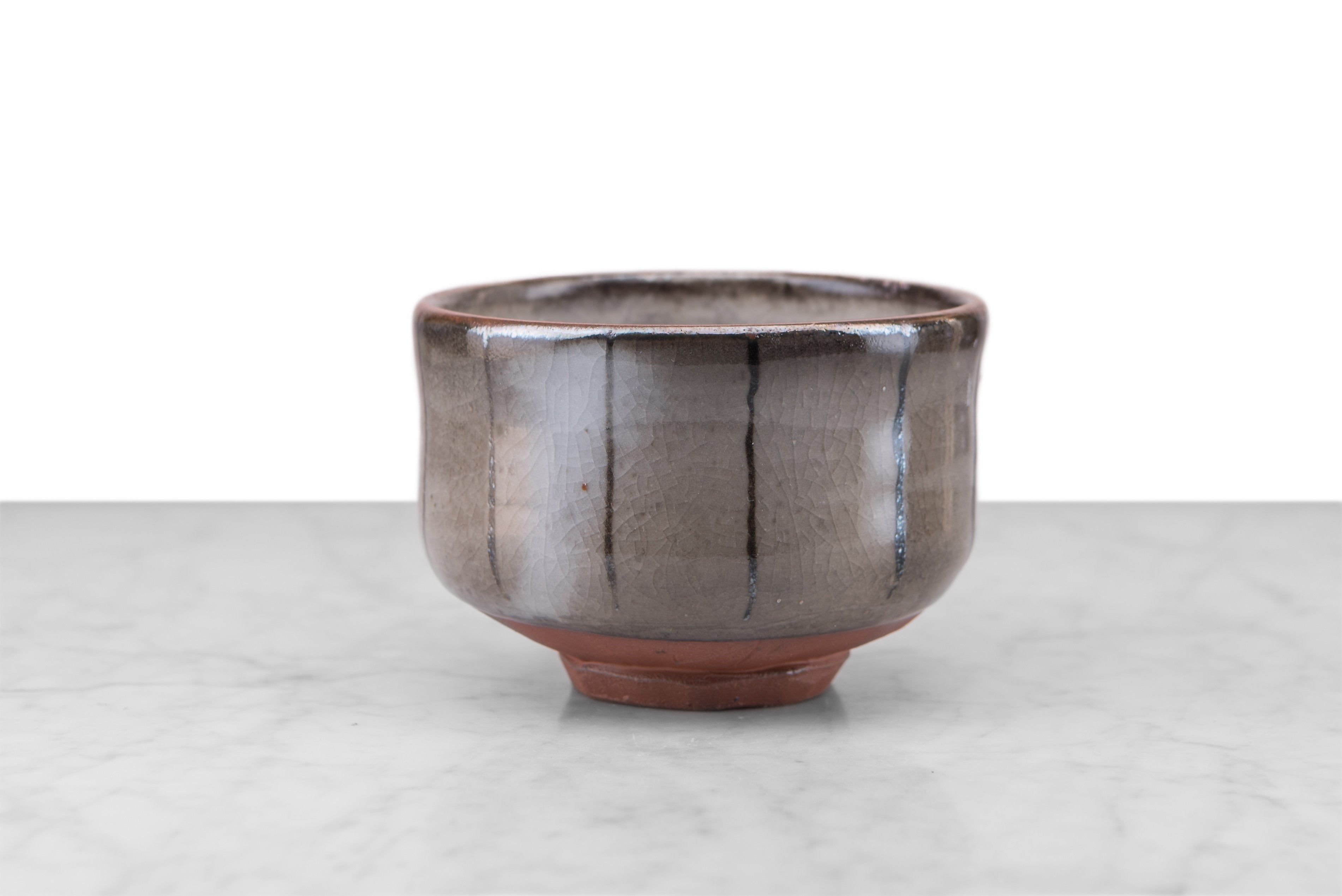grey and clay matcha bowl with dark gray vertical stripes