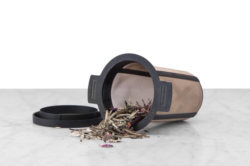 black fine mesh brewing basket displayed on side with top open and loose tea artfully spilling out