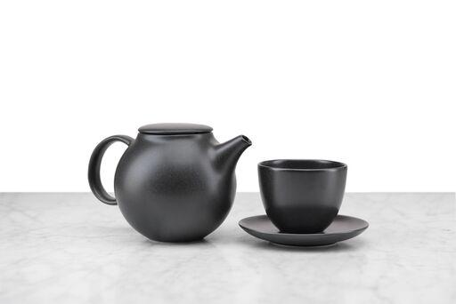 black minimalist teapot and matching handleless cup and saucer