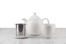 off-white tea set including teapot, infuser basket, infuser rest, and handleless tea cup