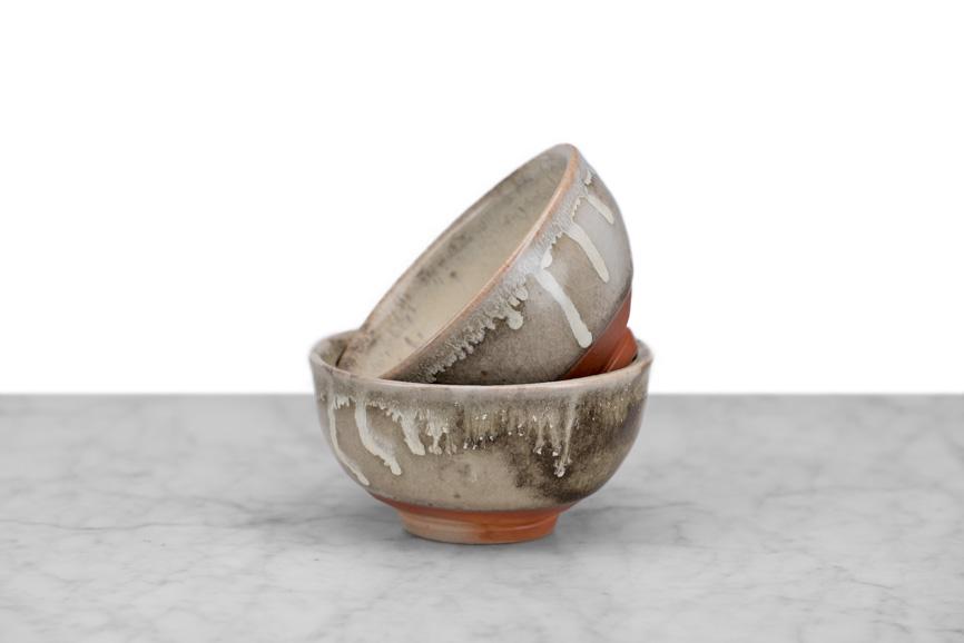stack of two hand thrown tea bowls with natural glaze color drips around rim