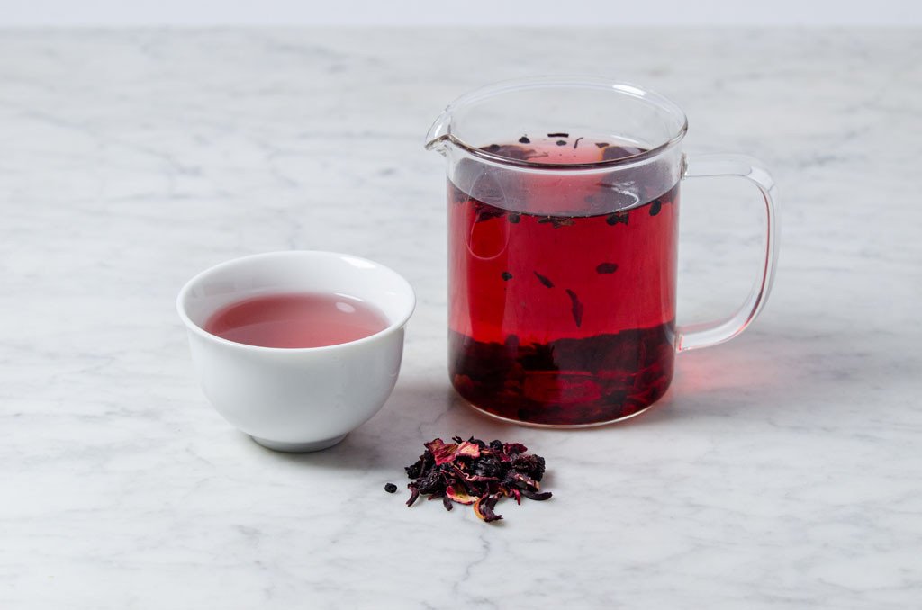 Crimson berry herbal tea in a white cup and glass infuser