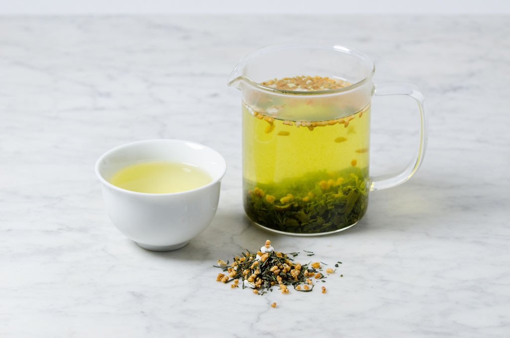 bright green infusion of genmai cha green tea brewed loose leaf in a glass infuser and white cup