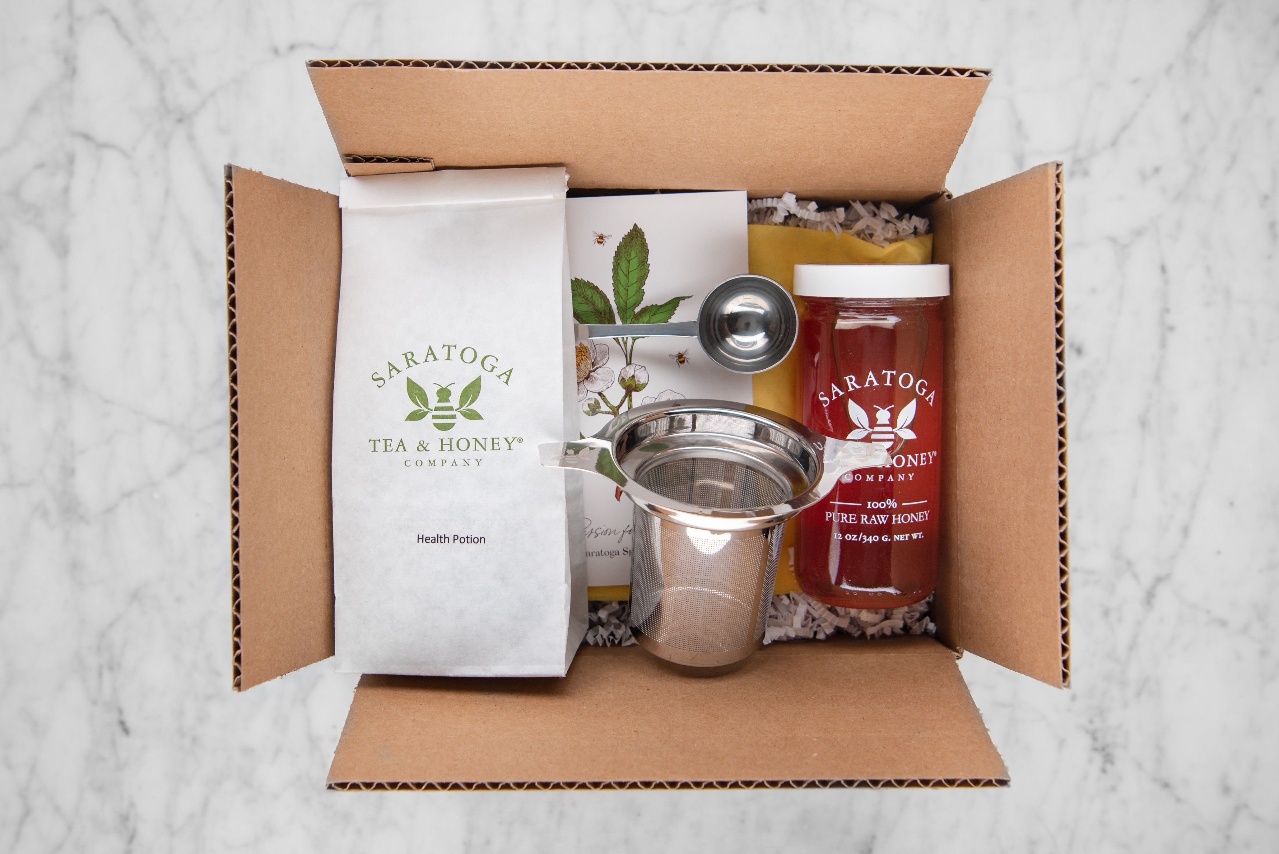 get well soon gift set featuring health potion herbal tisane, raw honey and stainless steel infuser