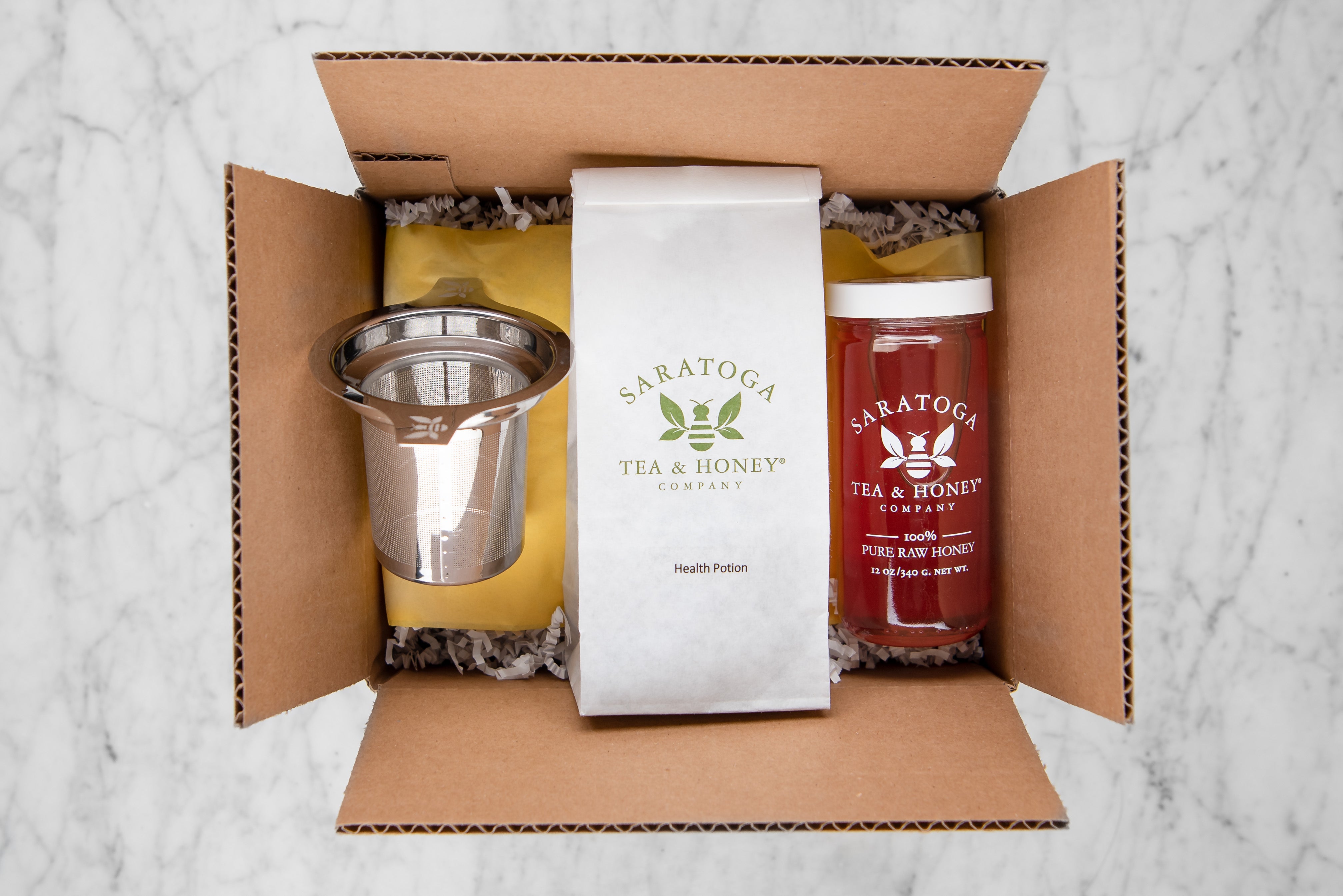 gift set with health potion tisane, stainless steel infuser, and raw honey