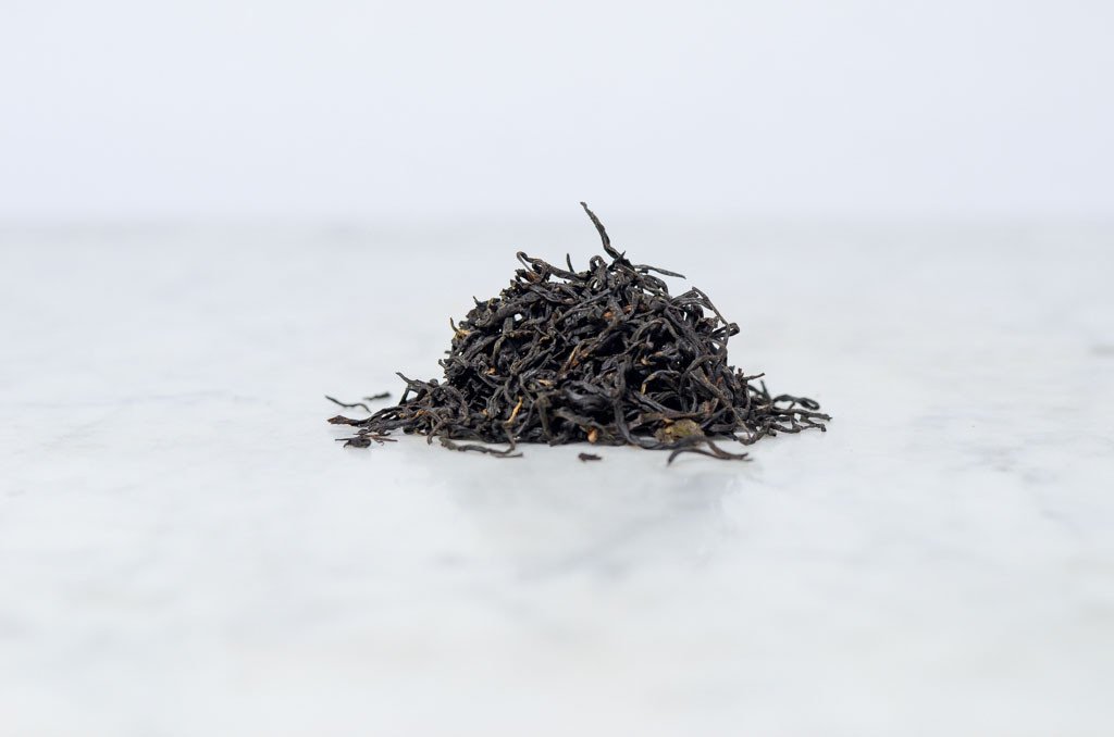 keemun mao feng loose leaf black tea piled on a marble background