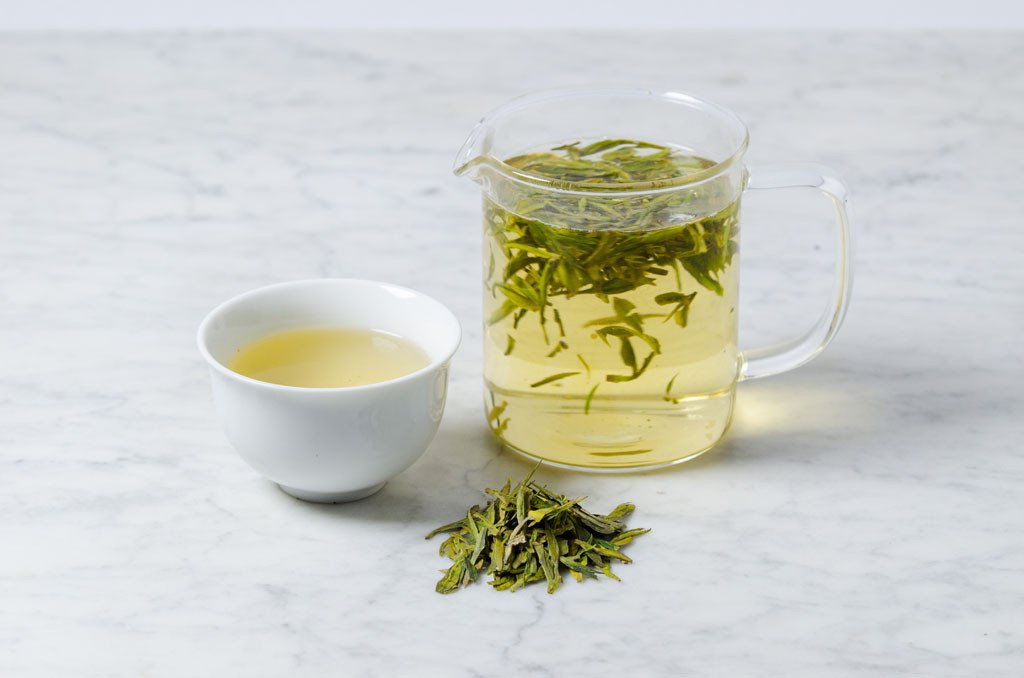 delicate chinenese Dragonwell green tea steeped in a glass infuser and white cup
