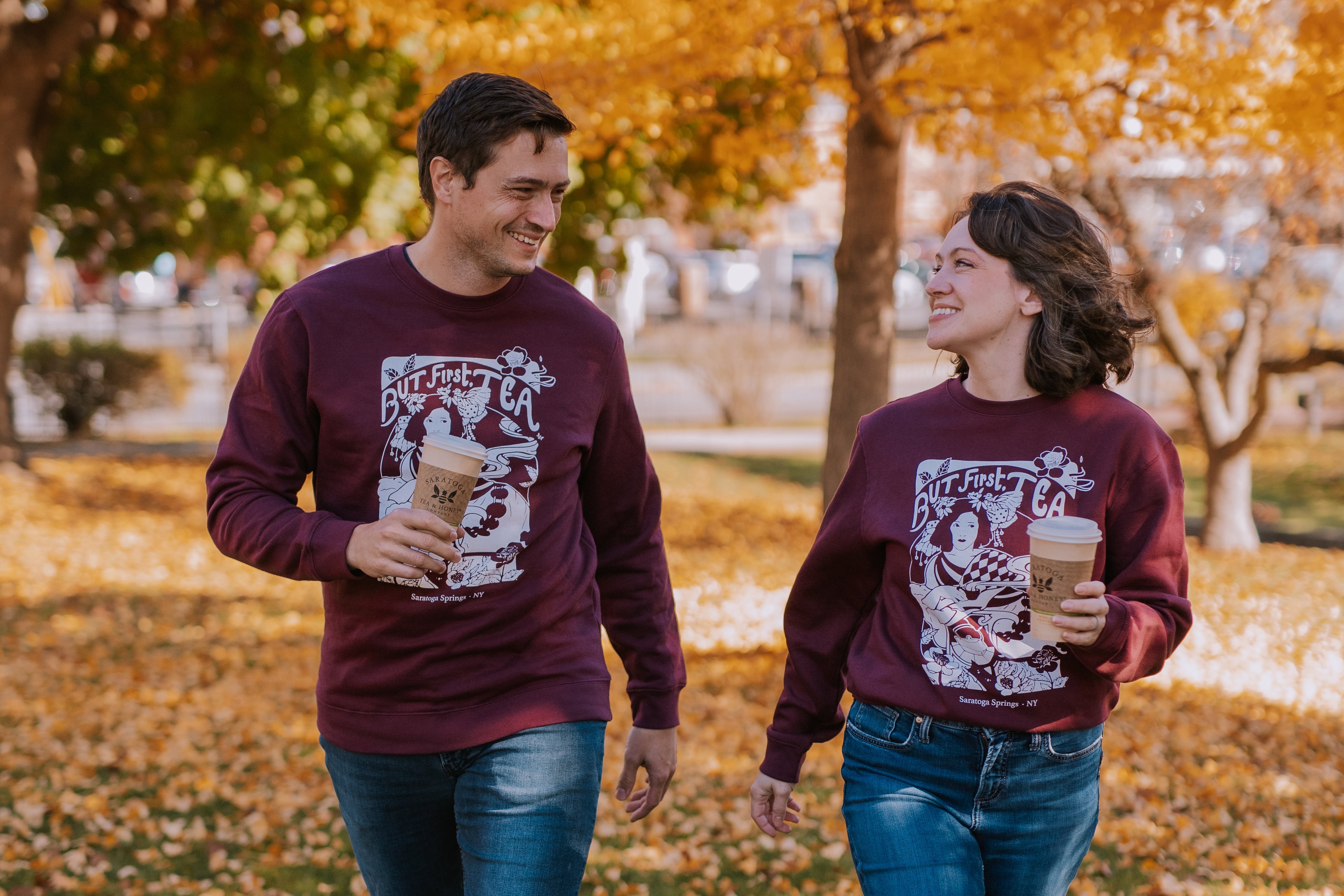 male and female wearing plum colored "but first, tea" art nouveau style printed sweatshirt