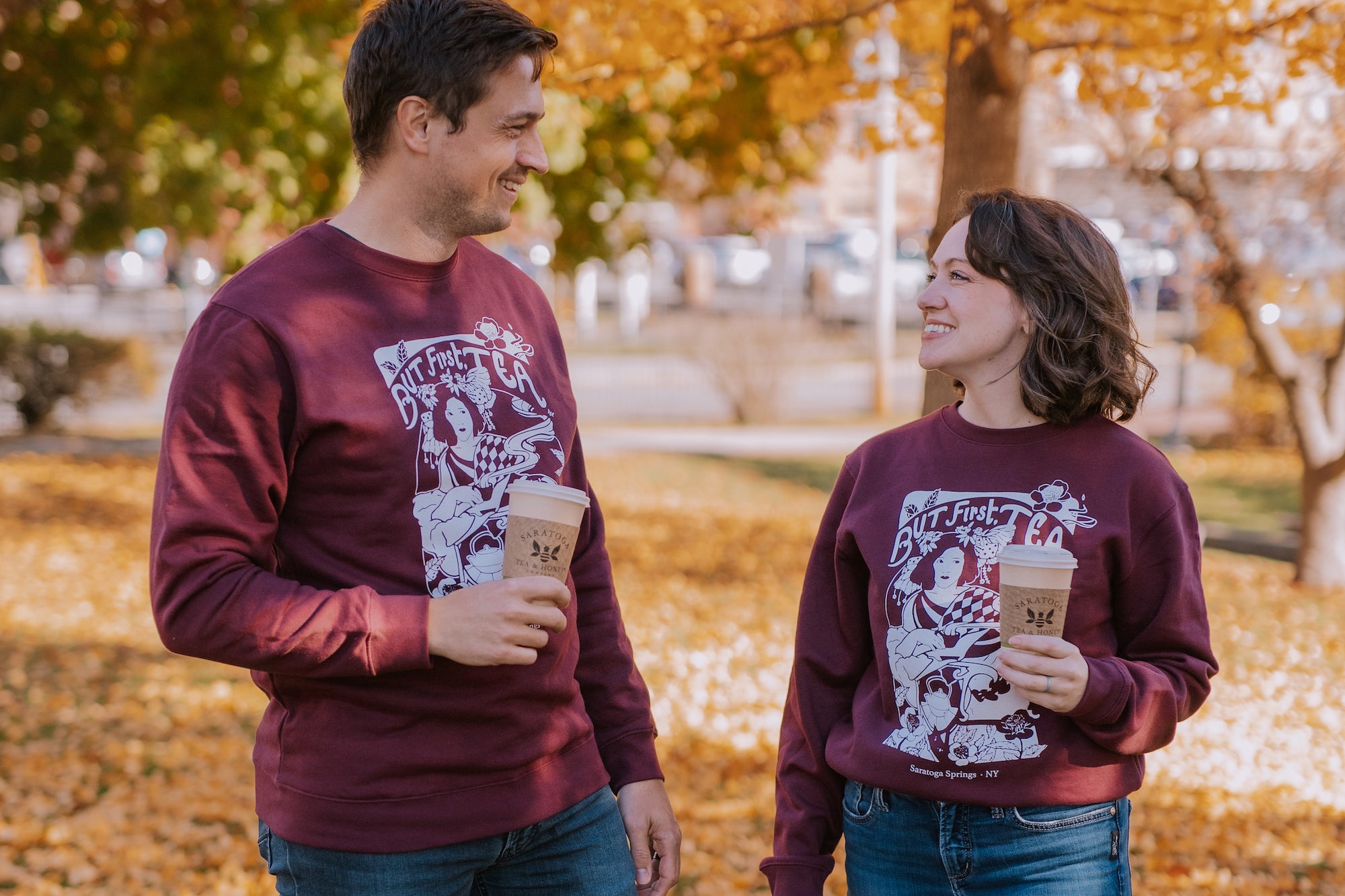 male and female wearing plum colored "but first, tea" art nouveau style printed sweatshirt