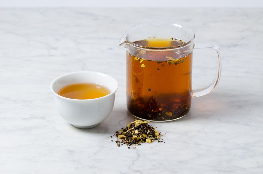 loose leaf chai tea brewed in a glass infuser and white cup
